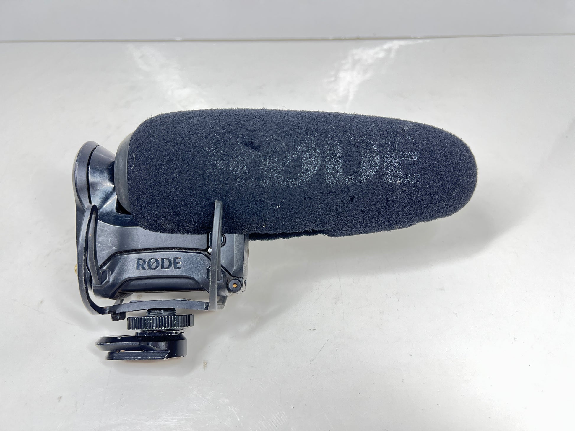 Used Rode VideoMic Pro shotgun microphone with damaged foam windscreen and visible onboard audio controls.