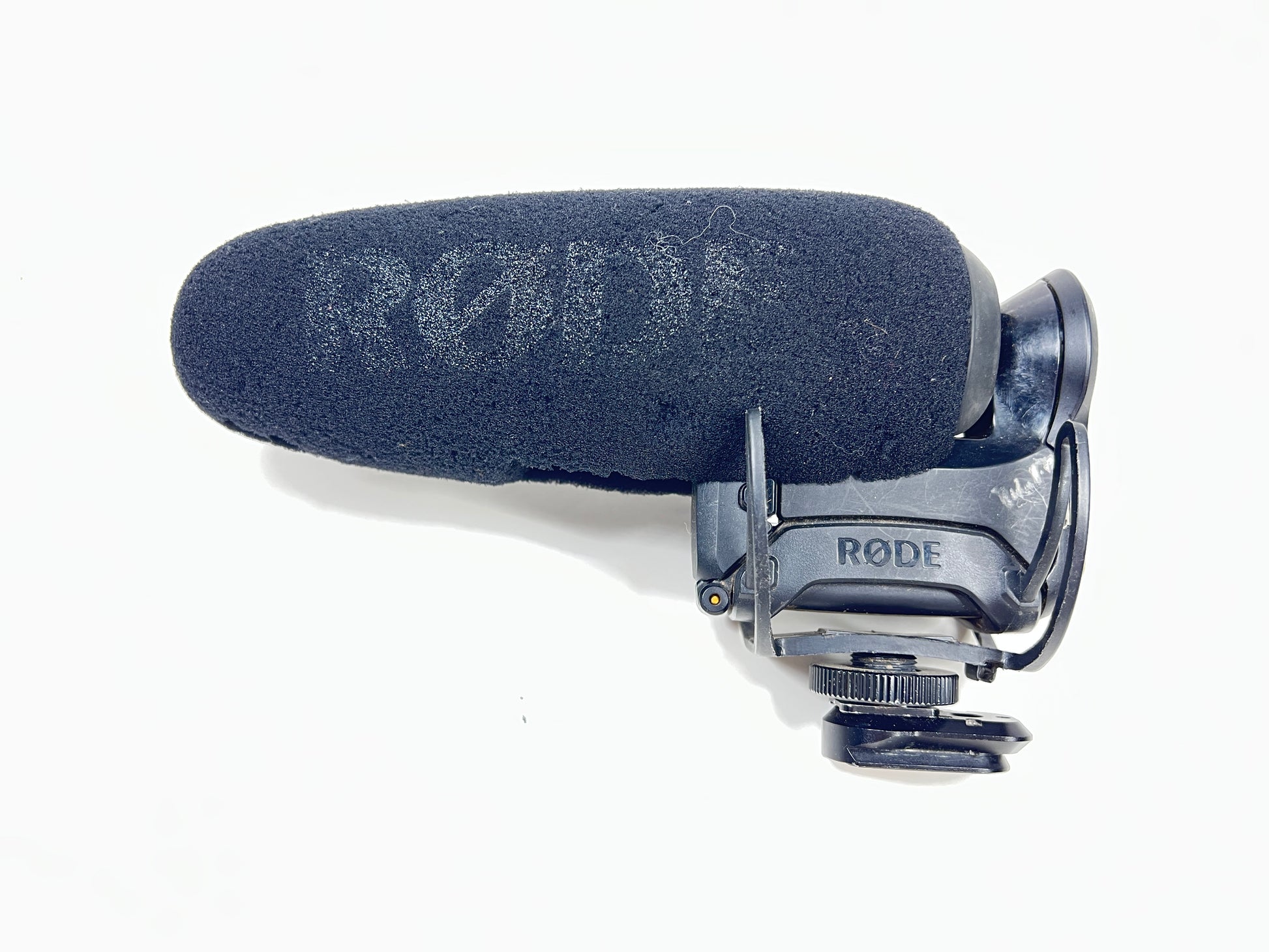 Used Rode VideoMic Pro shotgun microphone with damaged foam windscreen and visible onboard audio controls.