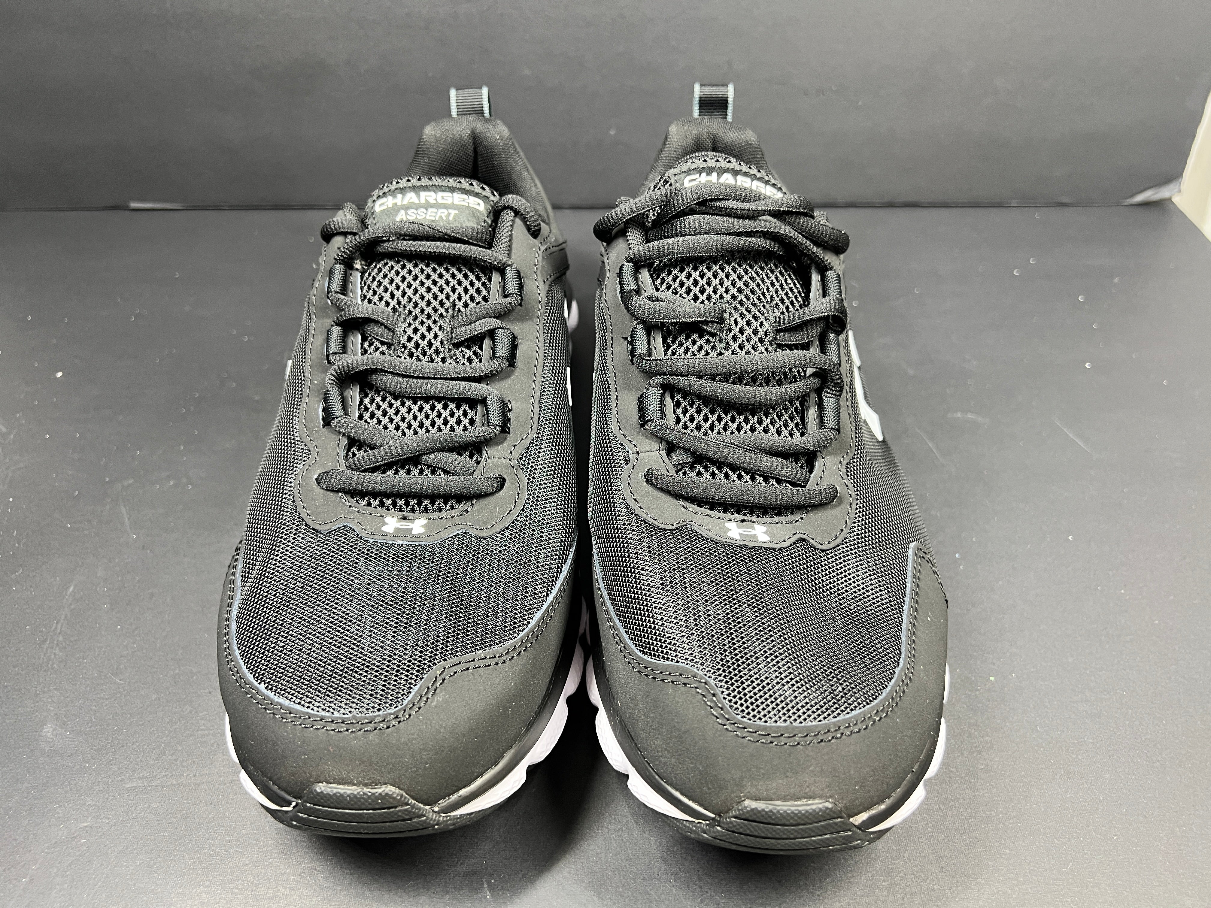 A pair of black Under Armour Charged Assert 9 running shoes for men