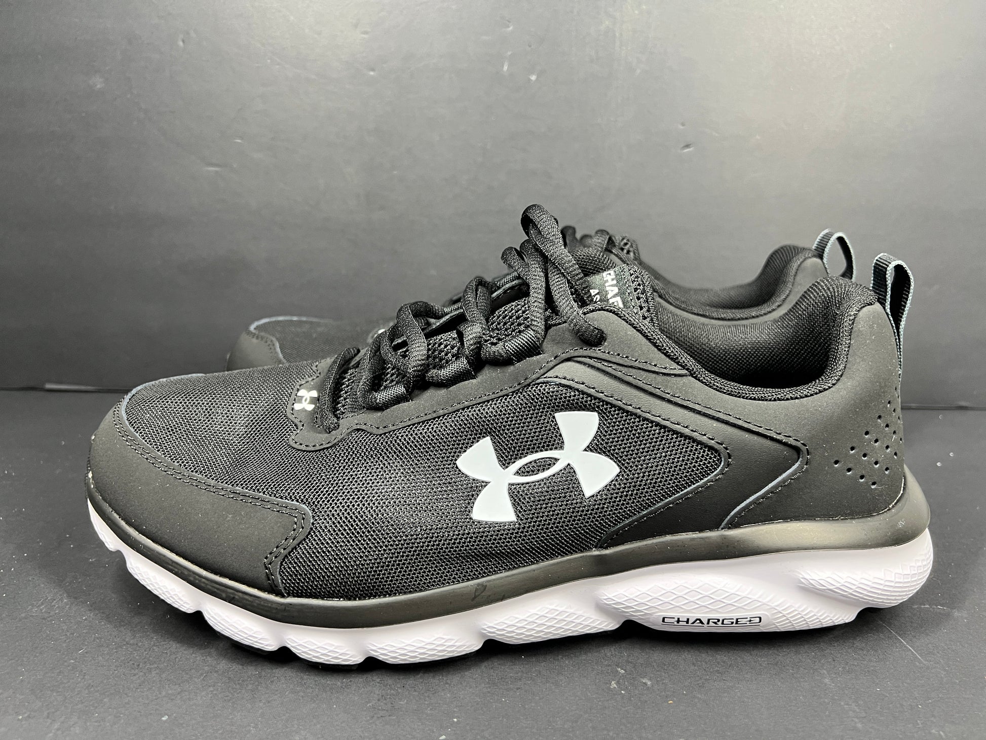 A pair of black Under Armour Charged Assert 9 running shoes for men
