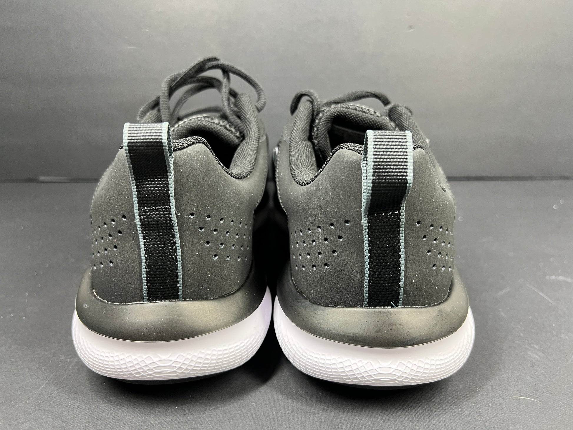 A pair of black Under Armour Charged Assert 9 running shoes for men