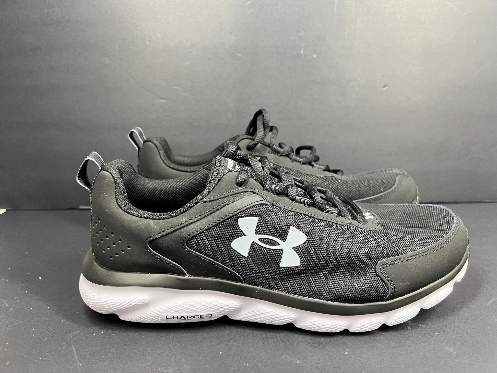 A pair of black Under Armour Charged Assert 9 running shoes for men