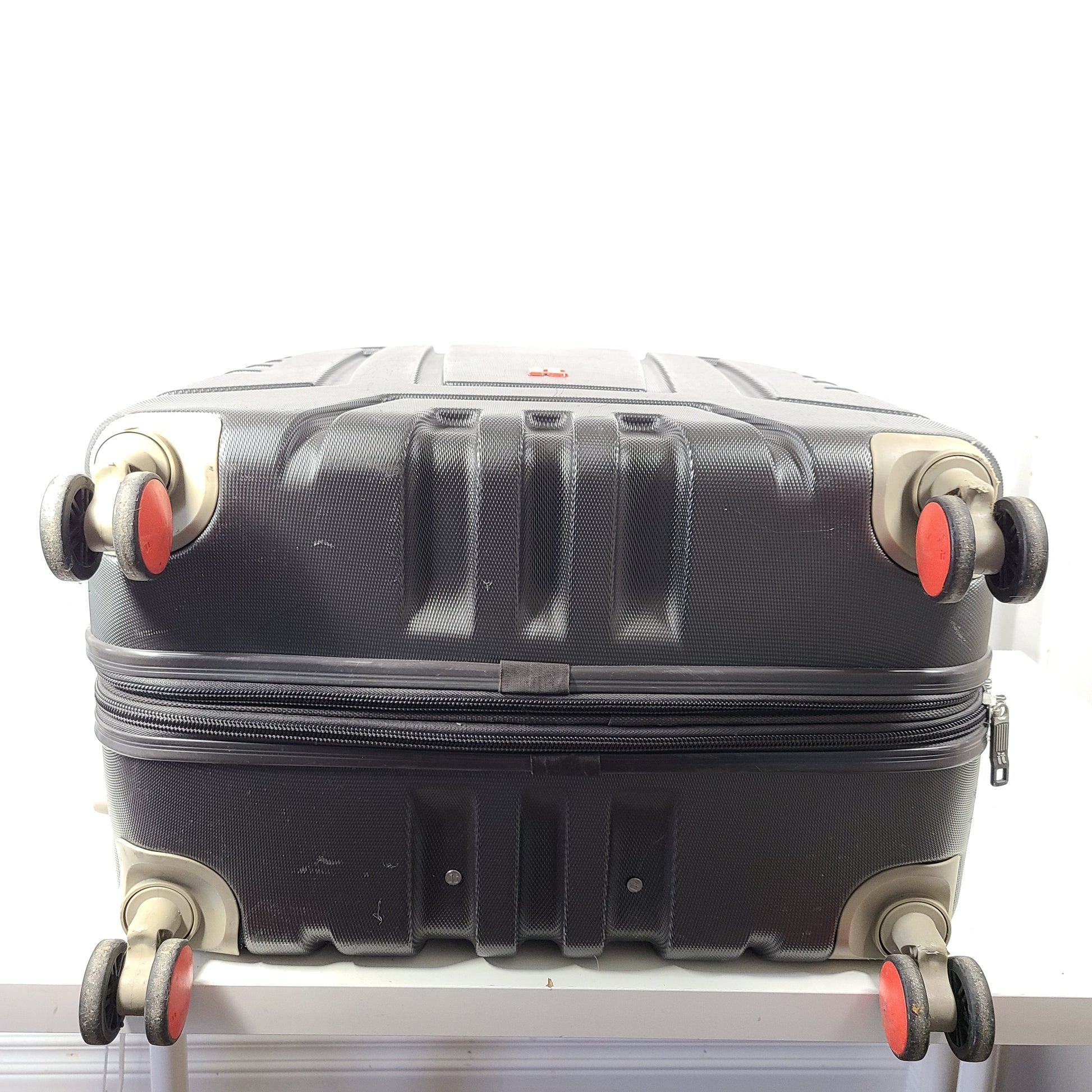 A red hard shell spinner suitcase by it Luggage