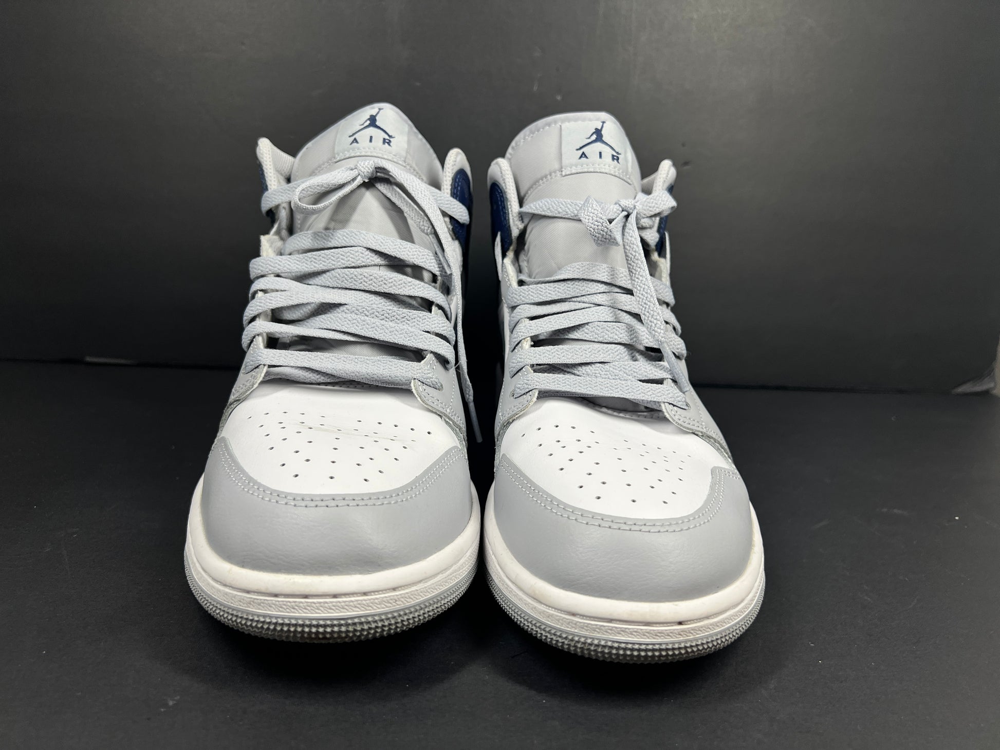 A pair of grey and white Nike Air Jordan Mid sneakers