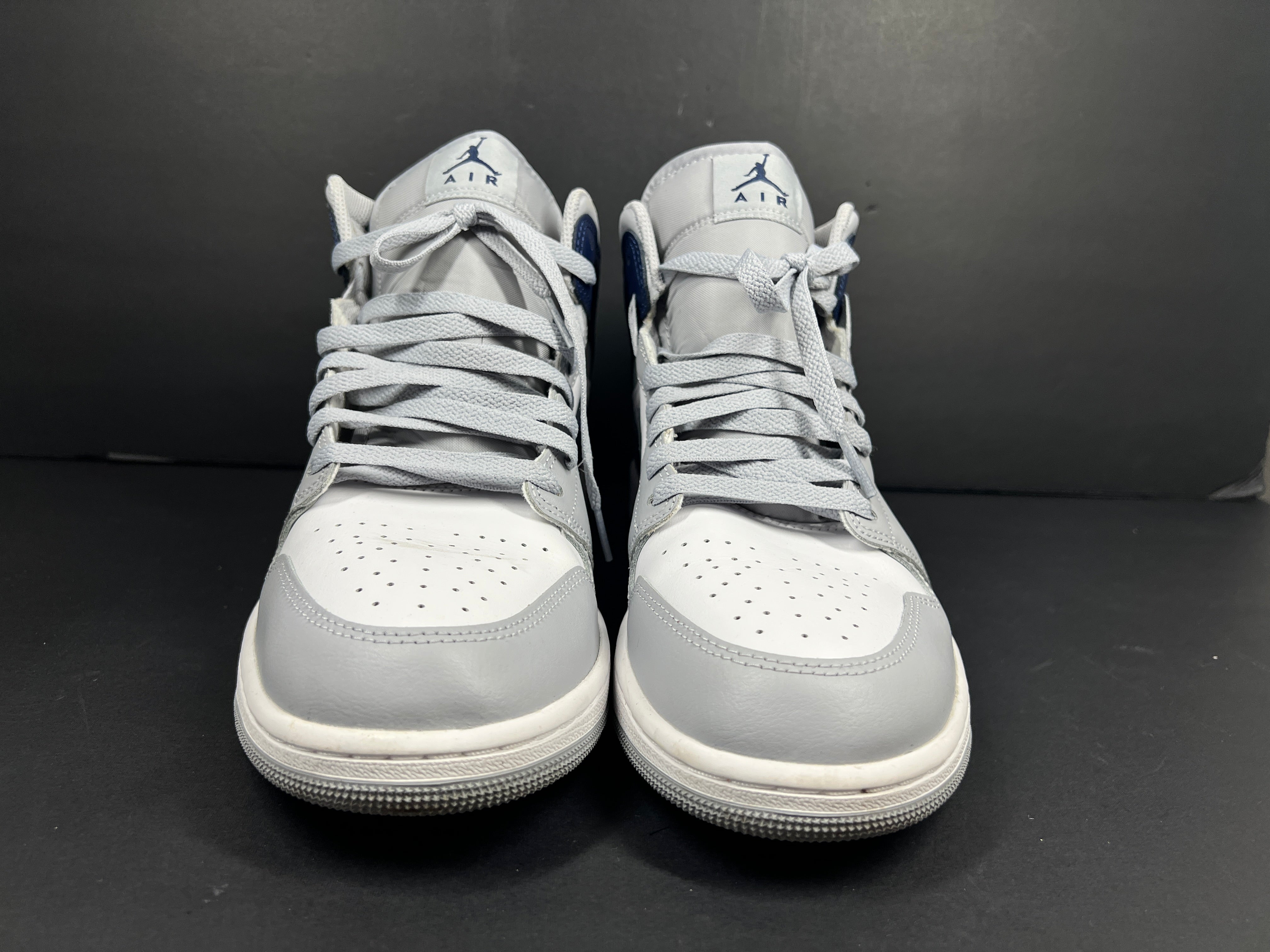 A pair of grey and white Nike Air Jordan Mid sneakers