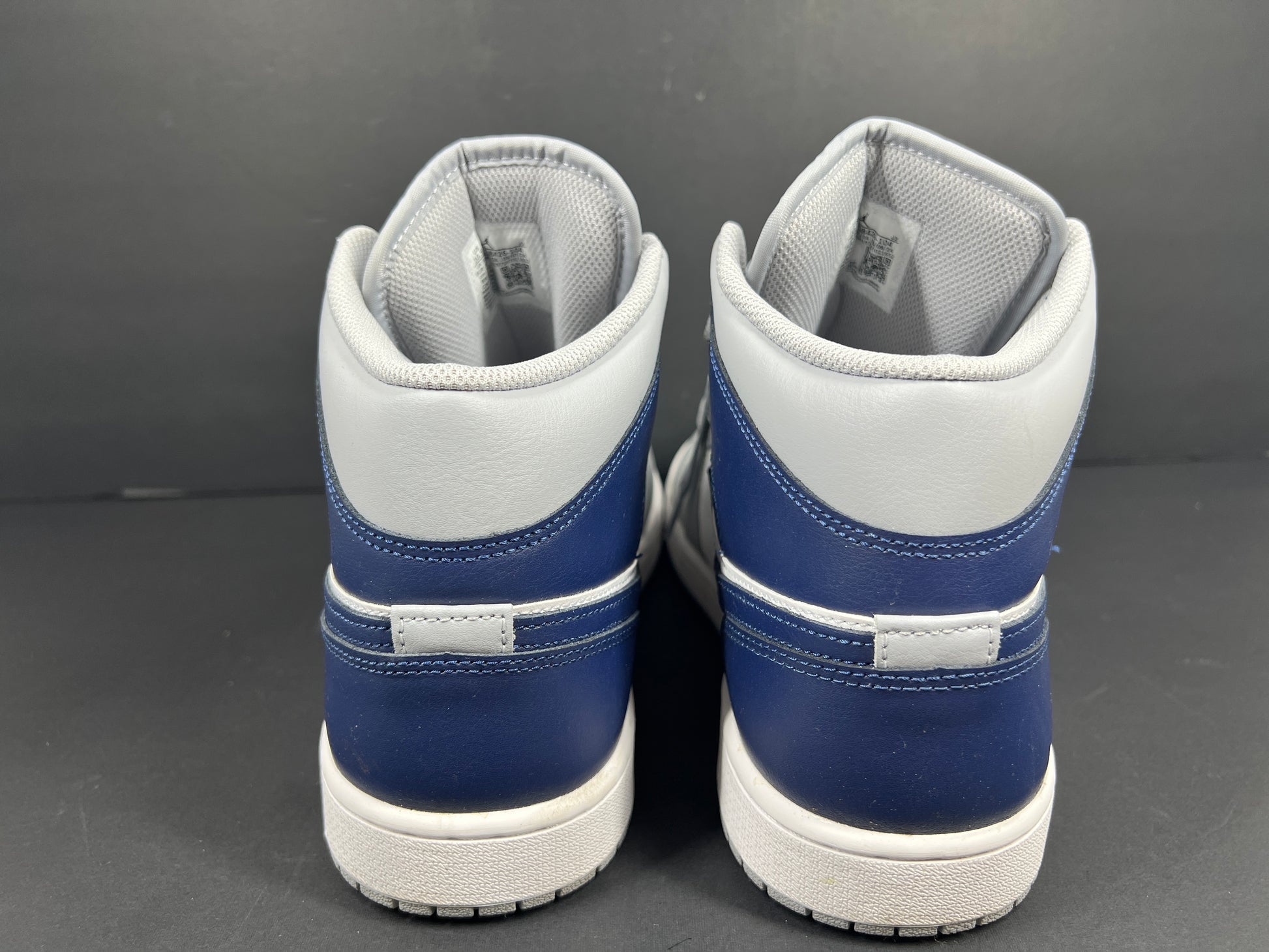 A pair of grey and white Nike Air Jordan Mid sneakers