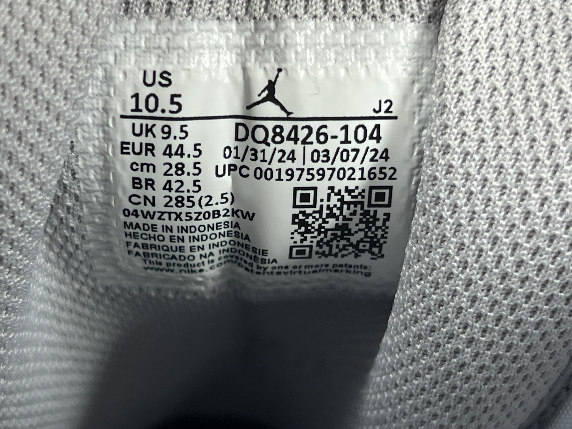 A pair of grey and white Nike Air Jordan Mid sneakers