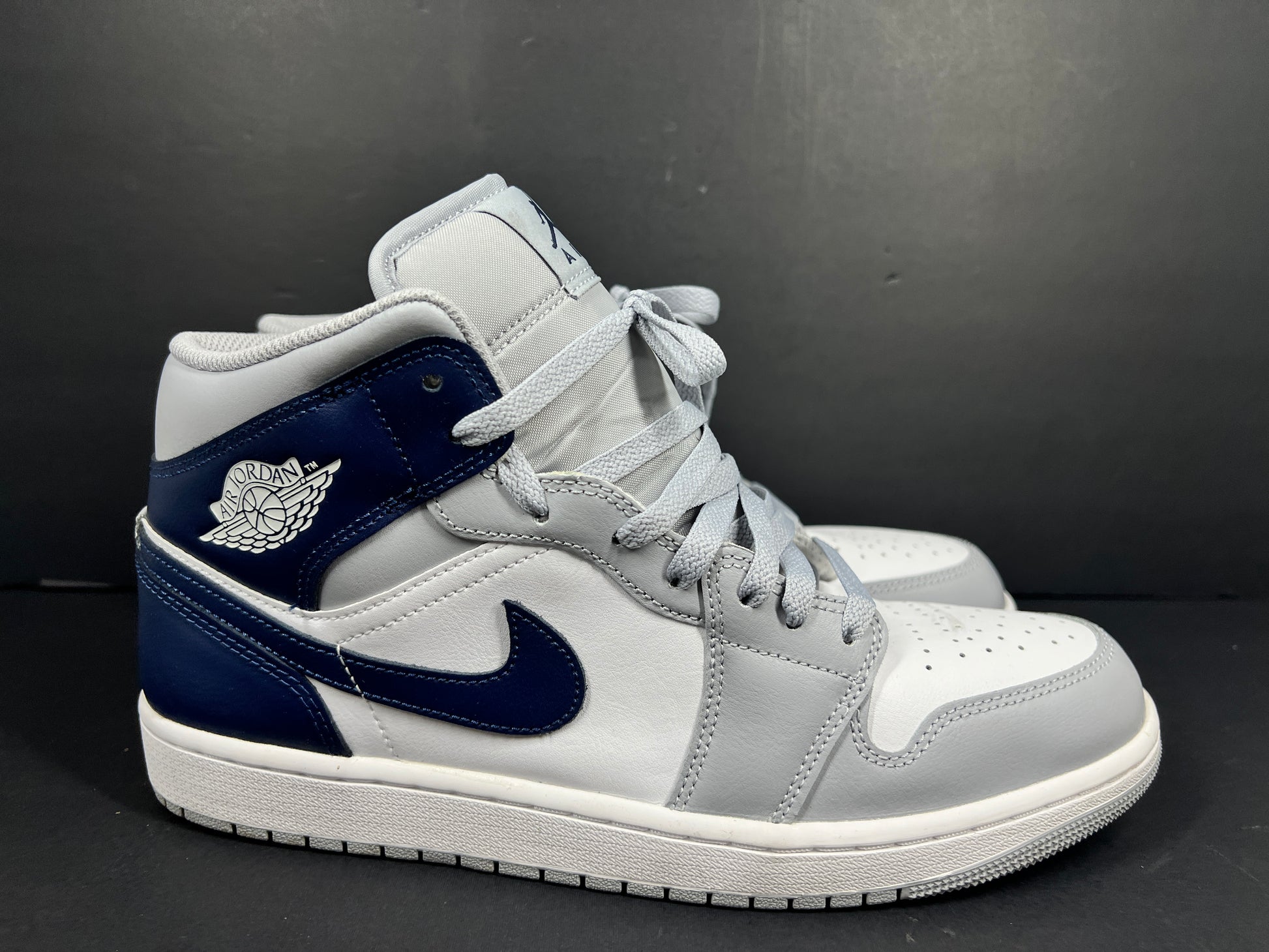 A pair of grey and white Nike Air Jordan Mid sneakers