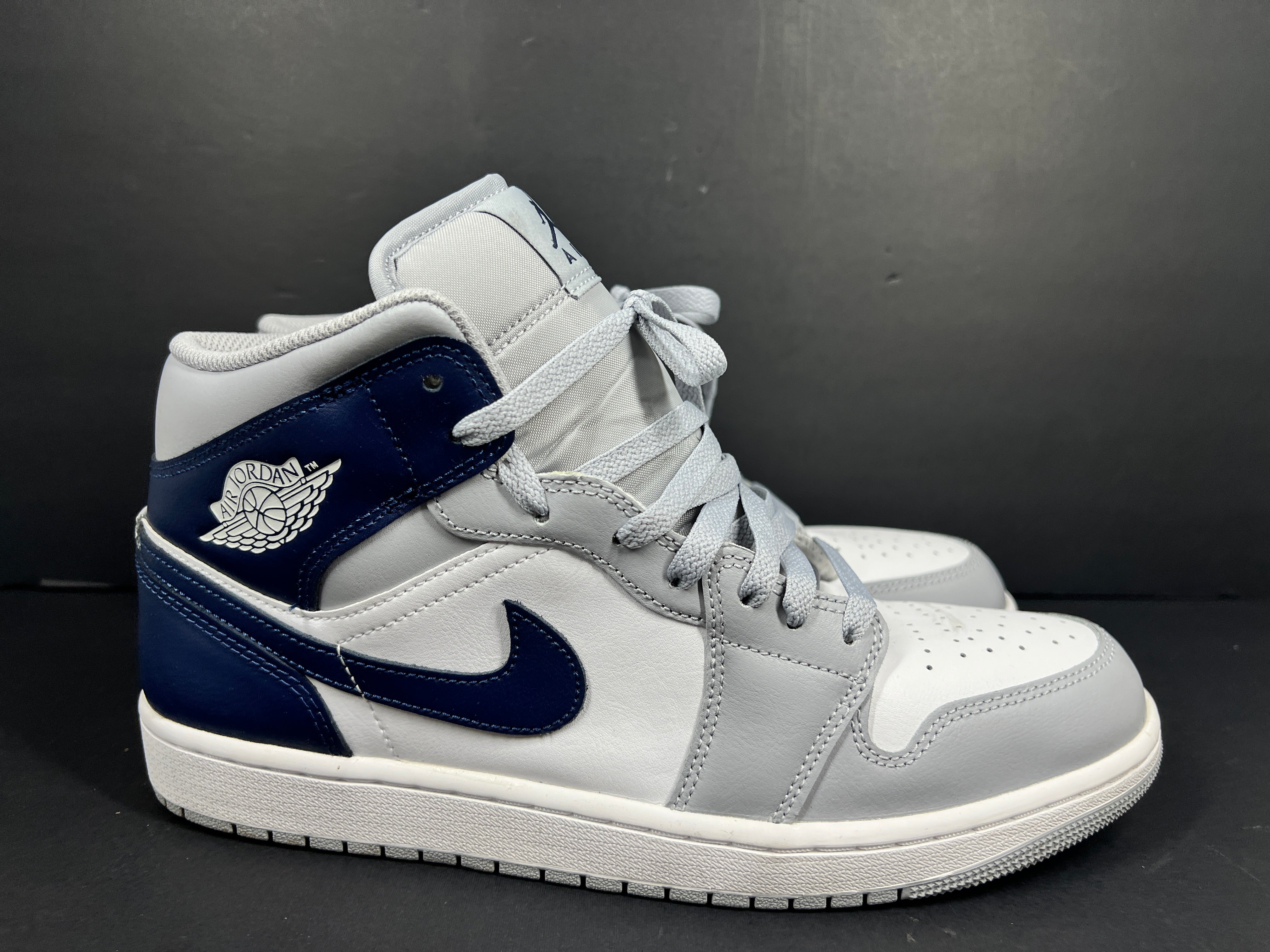 A pair of grey and white Nike Air Jordan Mid sneakers