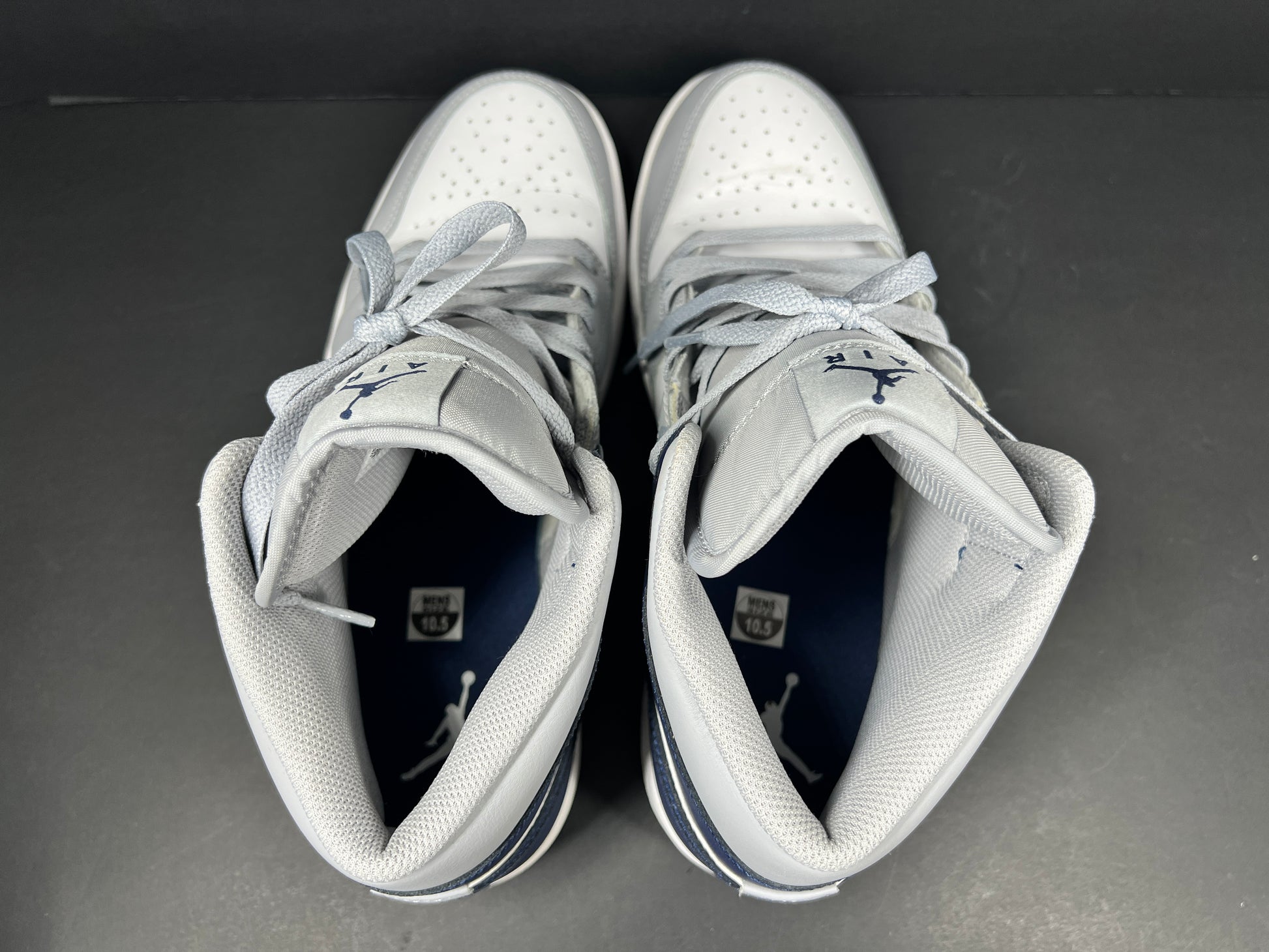 A pair of grey and white Nike Air Jordan Mid sneakers