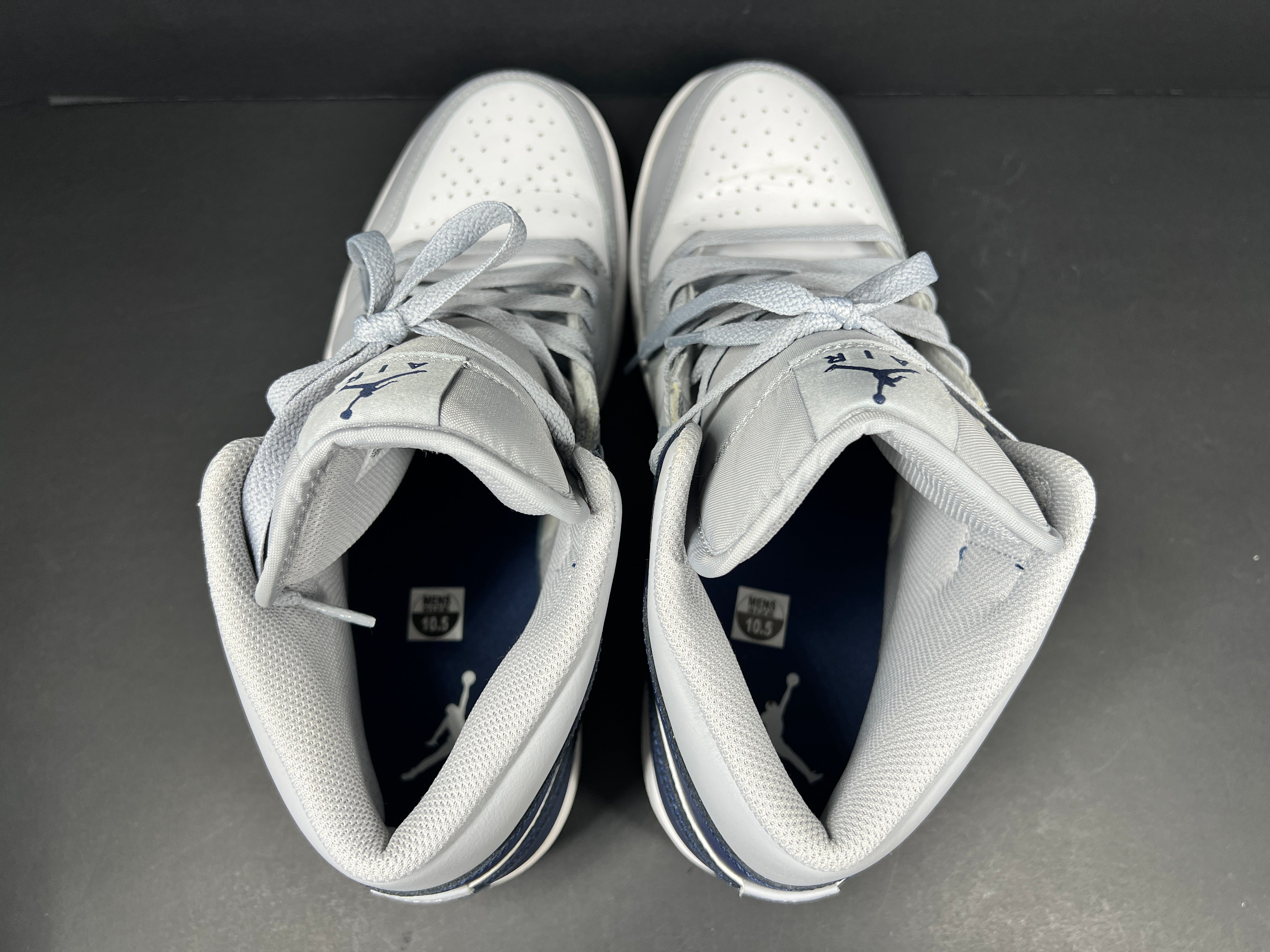 A pair of grey and white Nike Air Jordan Mid sneakers