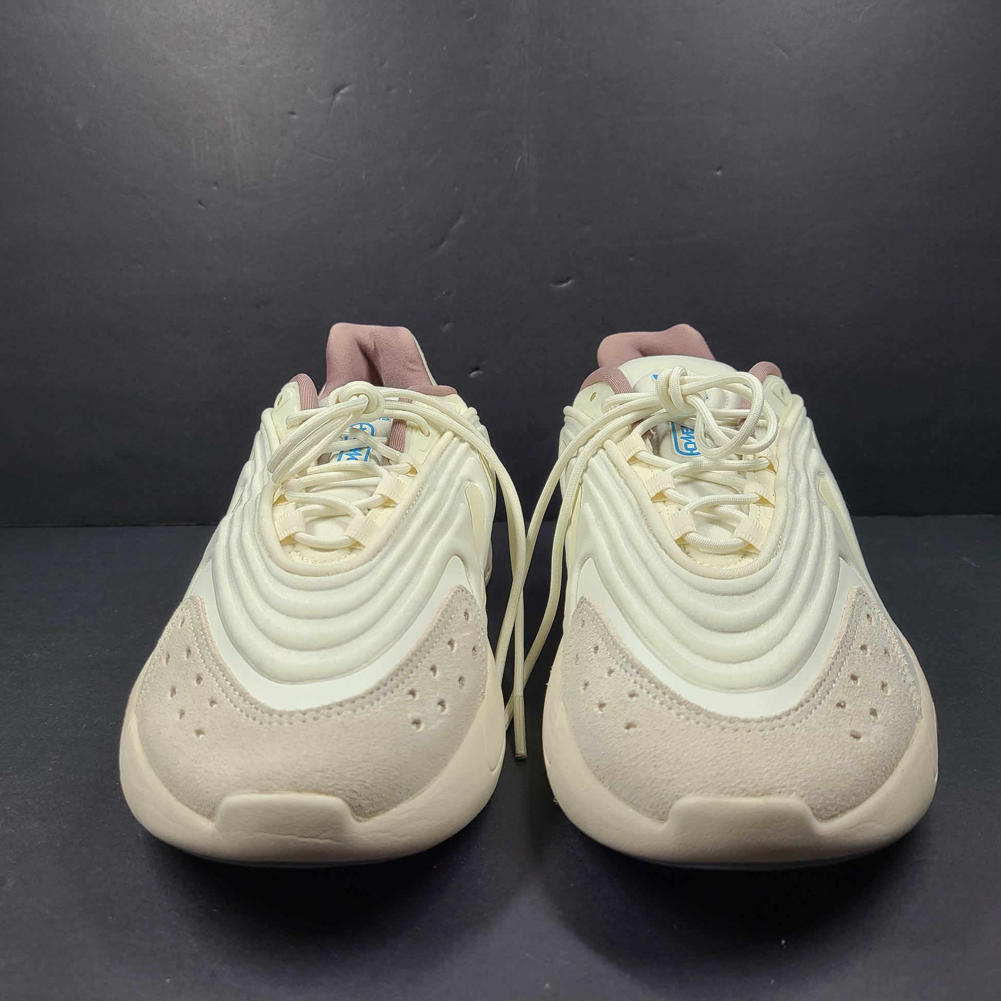 A pair of cream and blue Adidas adiPRENE sneakers in size 9.5 for men.