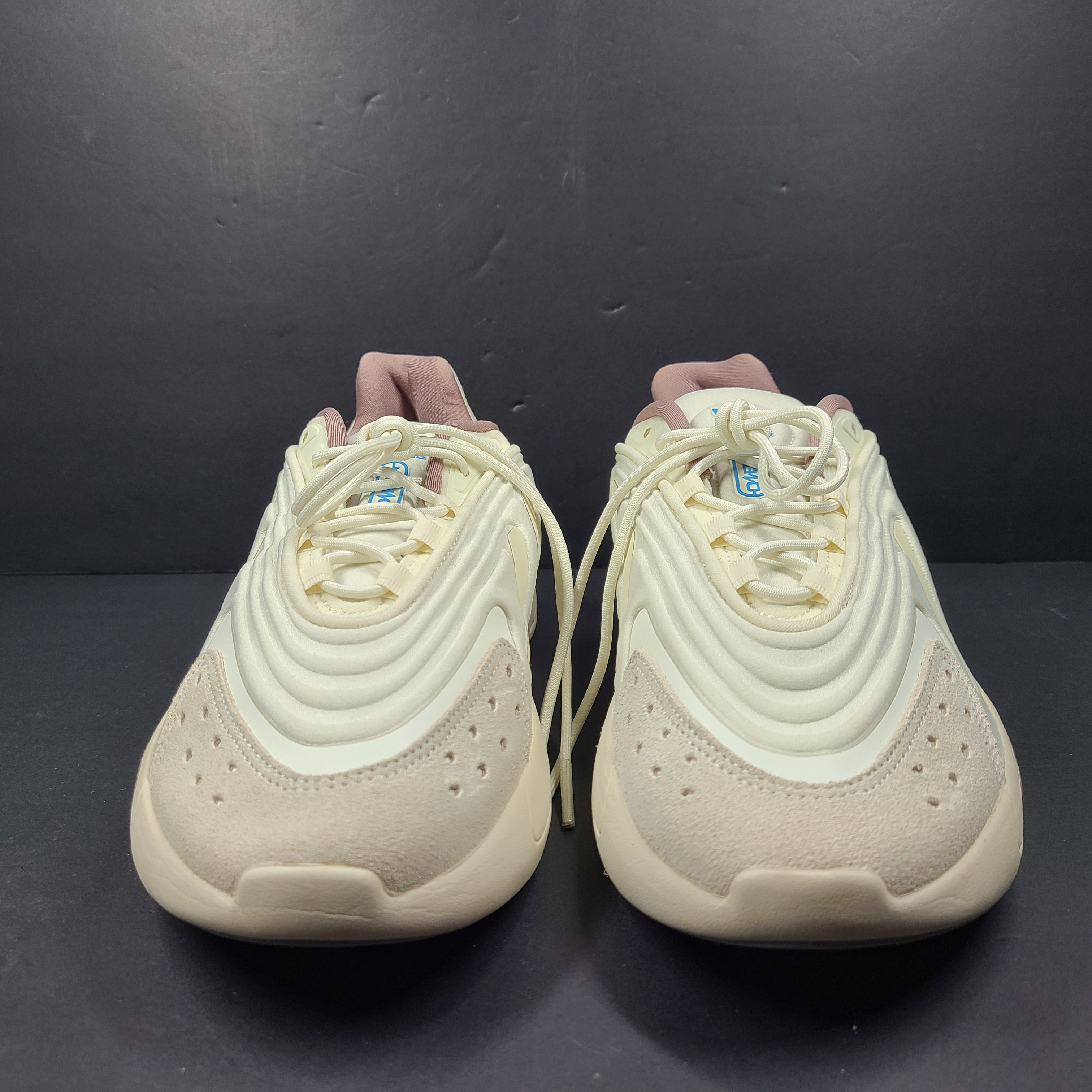 A pair of cream and blue Adidas adiPRENE sneakers in size 9.5 for men.