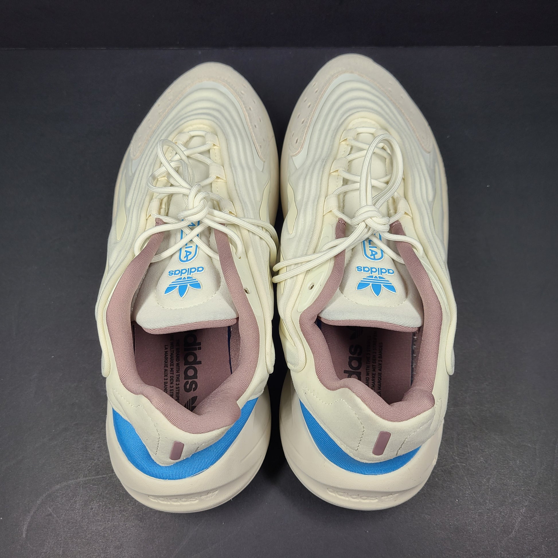 A pair of cream and blue Adidas adiPRENE sneakers in size 9.5 for men.