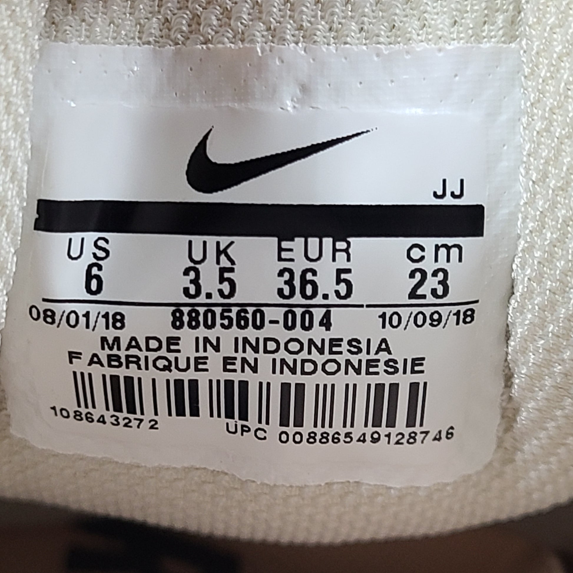 A pair of beige Nike Zoom running shoes.