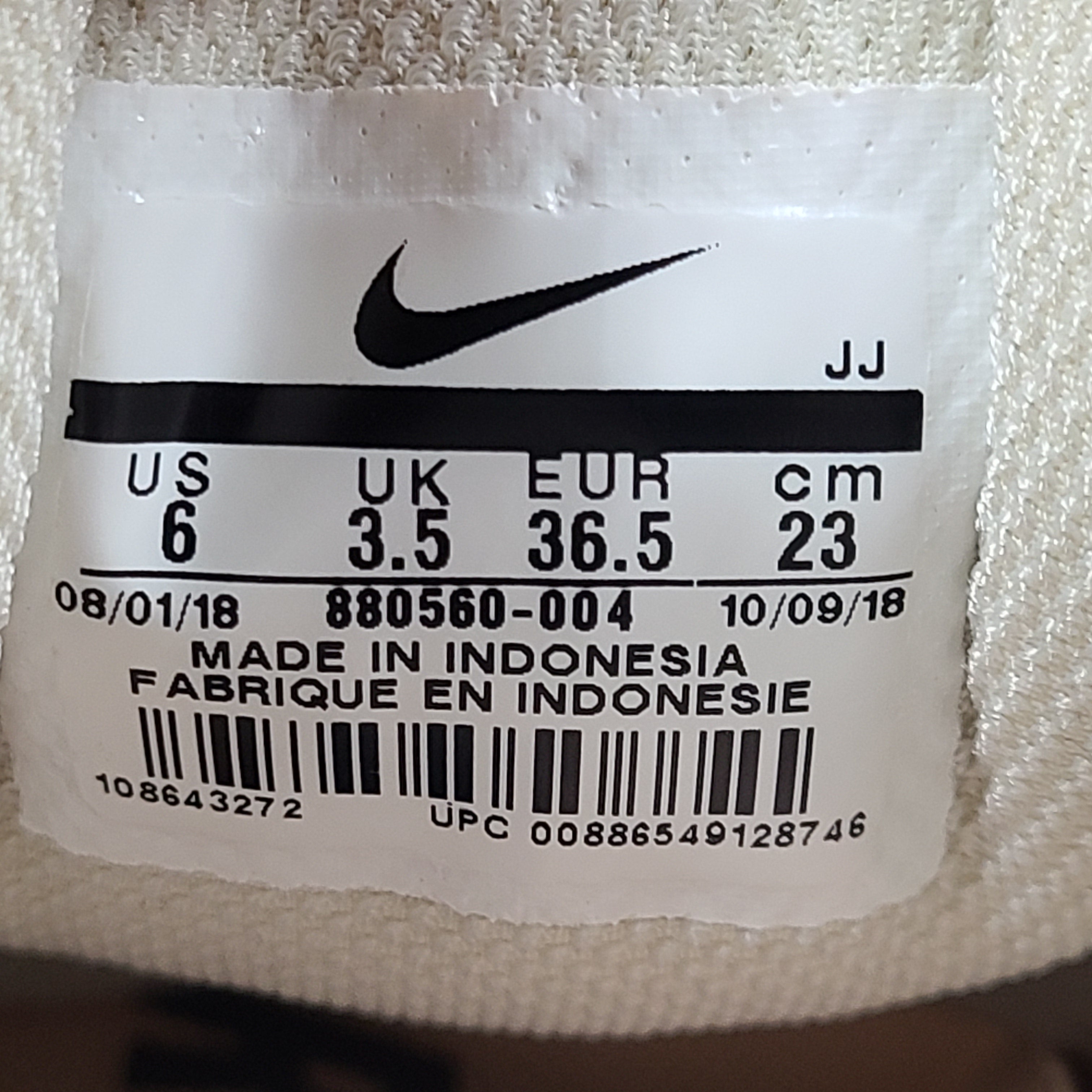 A pair of beige Nike Zoom running shoes.