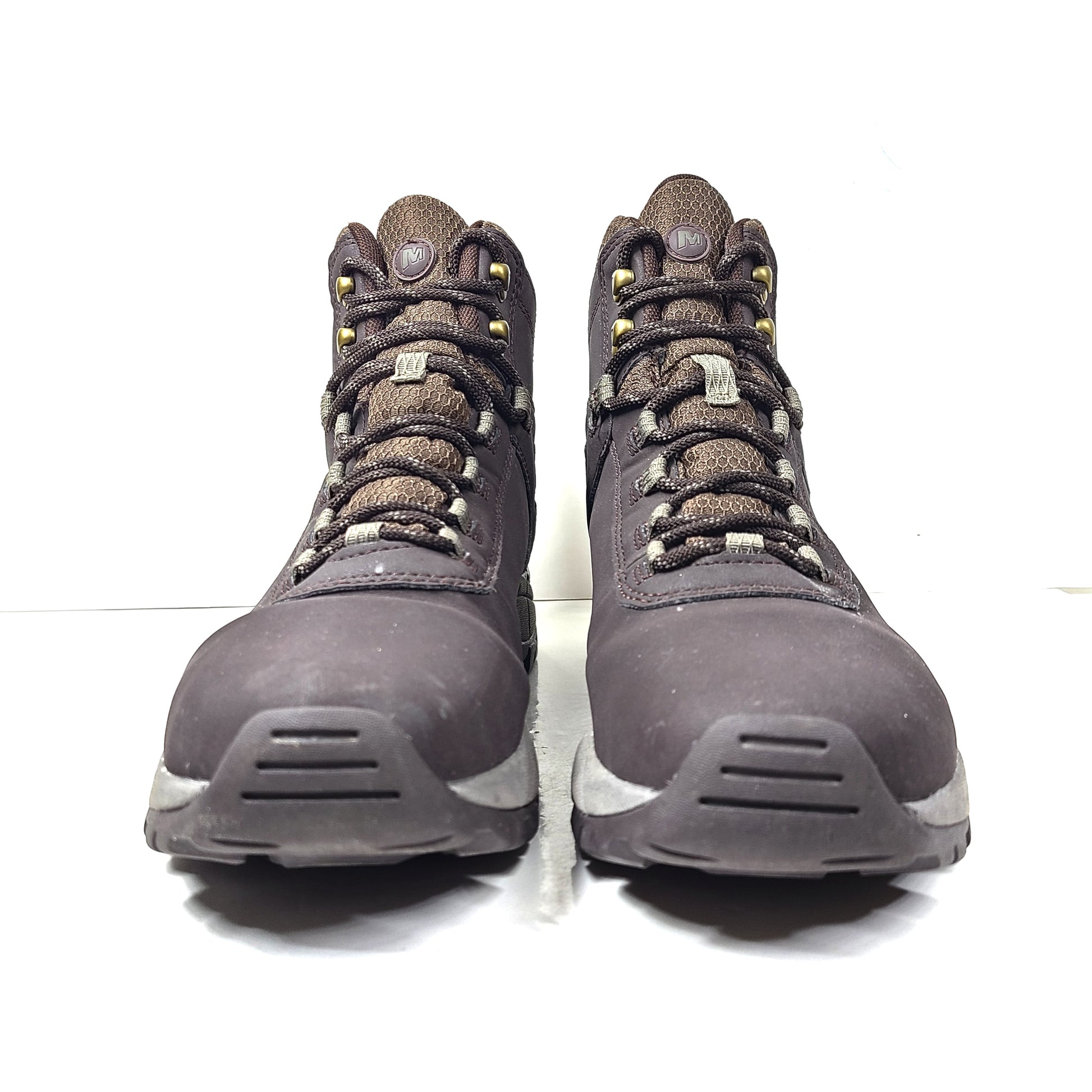 A pair of brown Merrell men's waterproof hiking boots on a rugged trail.