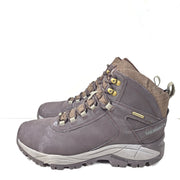 A pair of brown Merrell men's waterproof hiking boots on a rugged trail.