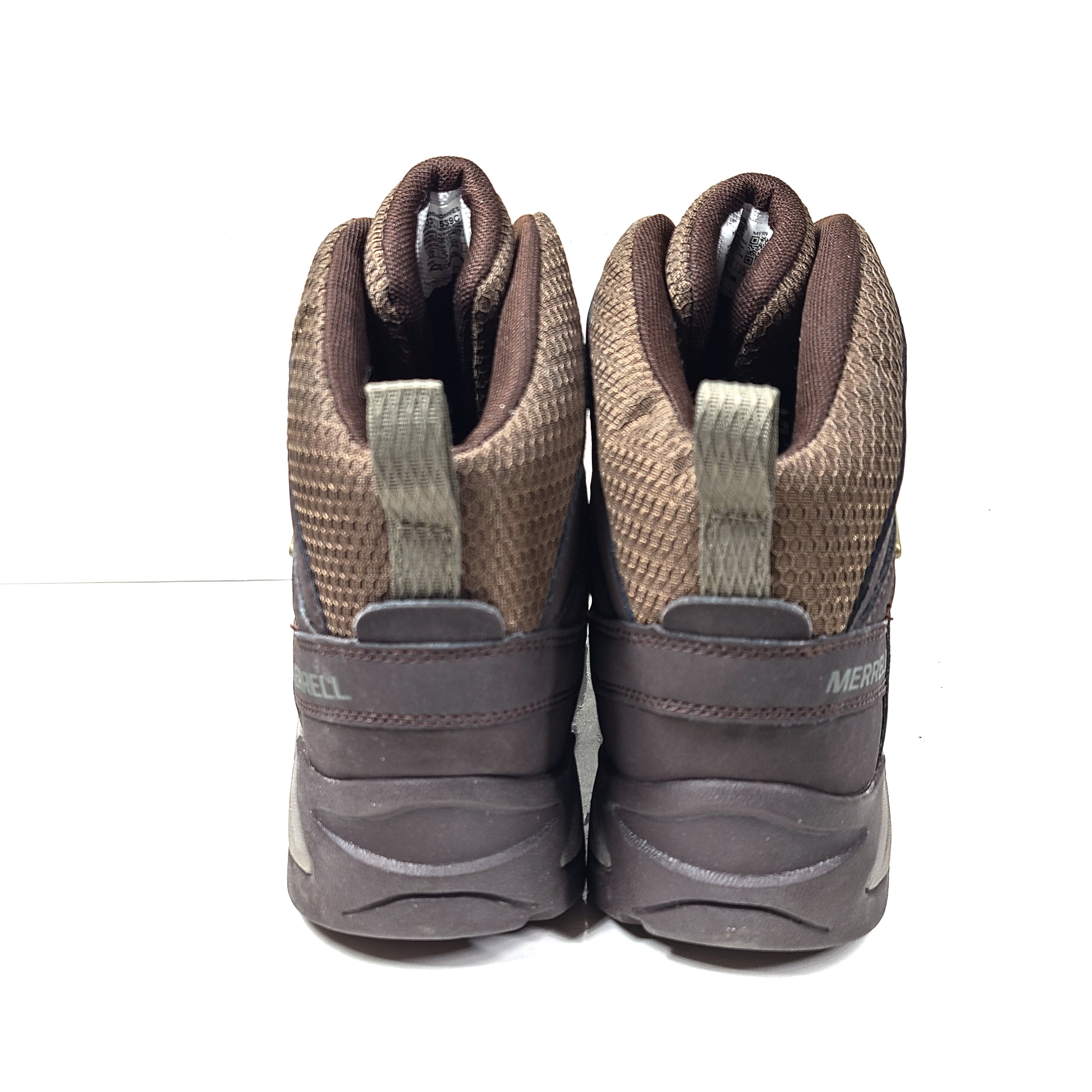 A pair of brown Merrell men's waterproof hiking boots on a rugged trail.