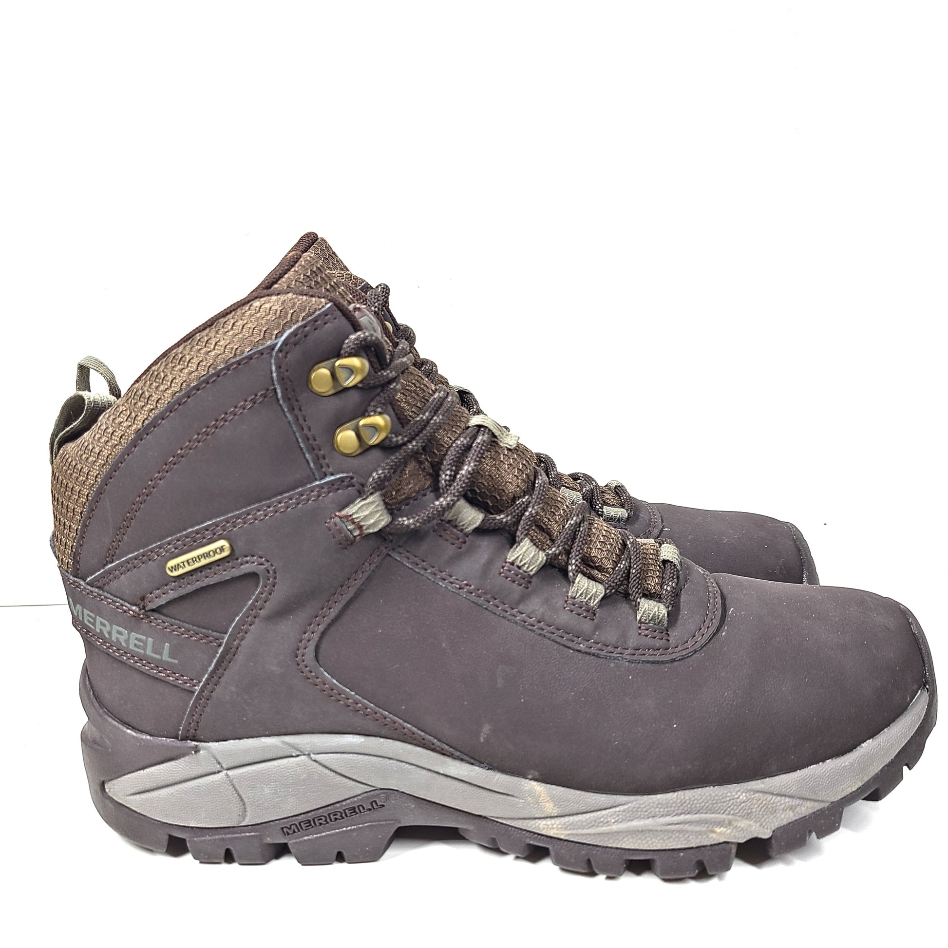 A pair of brown Merrell men's waterproof hiking boots on a rugged trail.