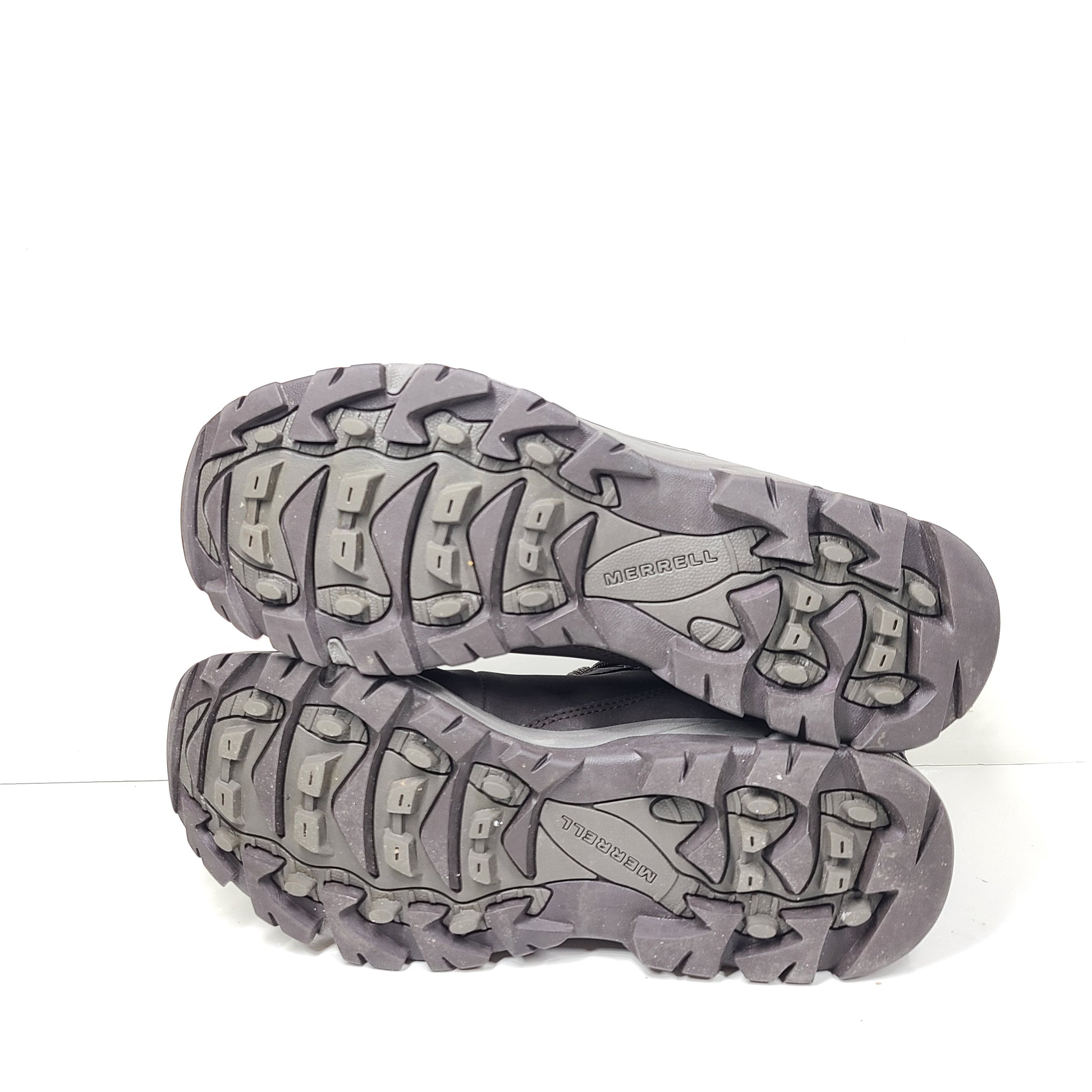A pair of brown Merrell men's waterproof hiking boots on a rugged trail.