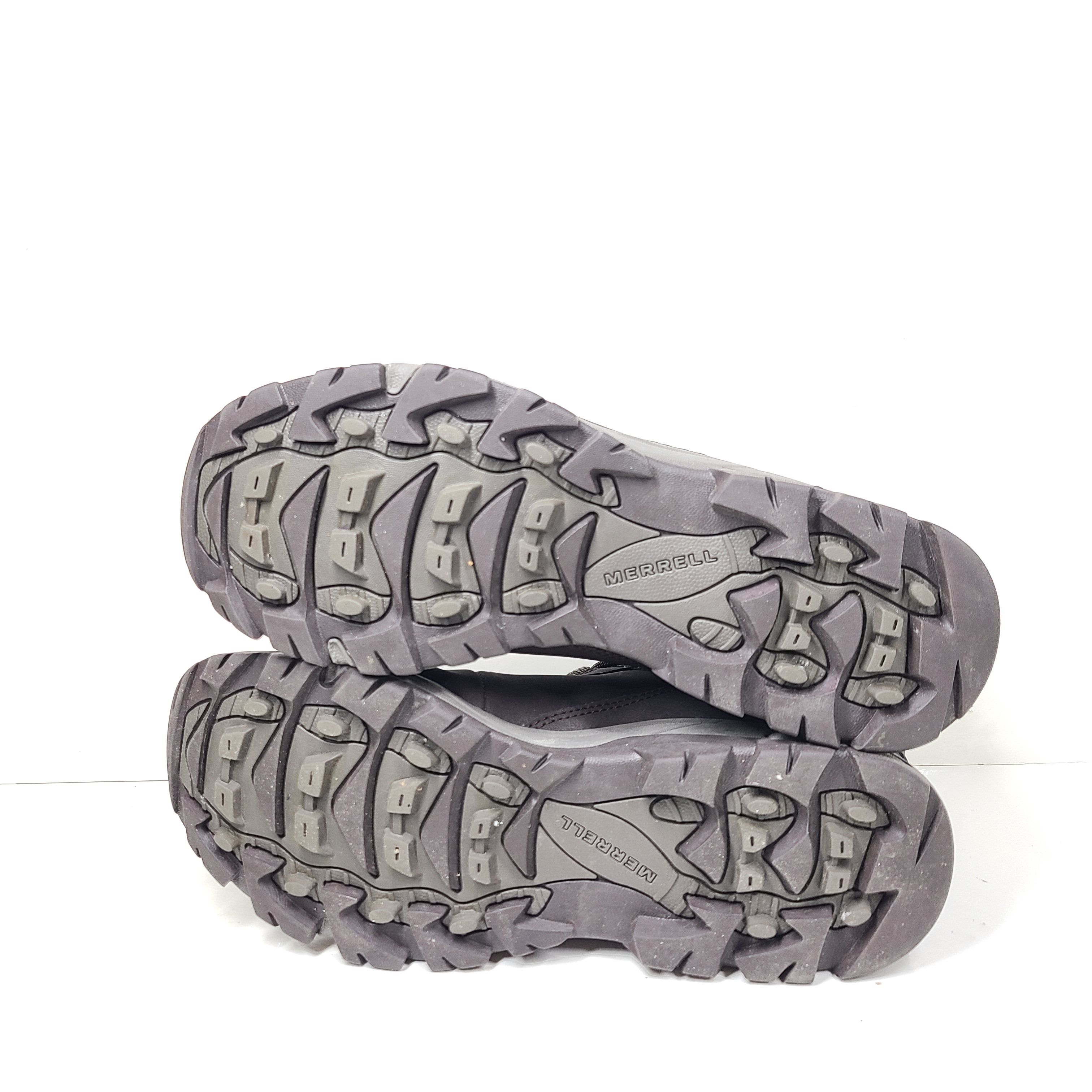 A pair of brown Merrell men's waterproof hiking boots on a rugged trail.