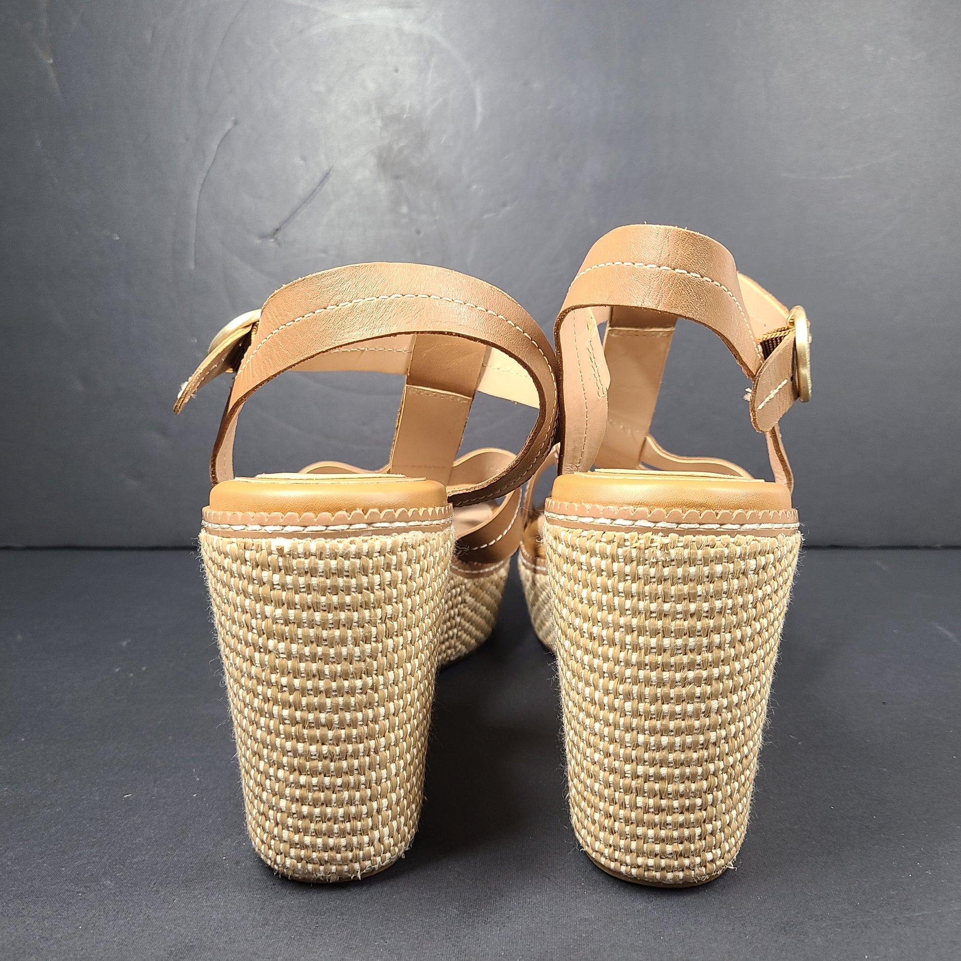 A pair of tan Cole Haan Cloudfeel Grandseries wedge sandals for women