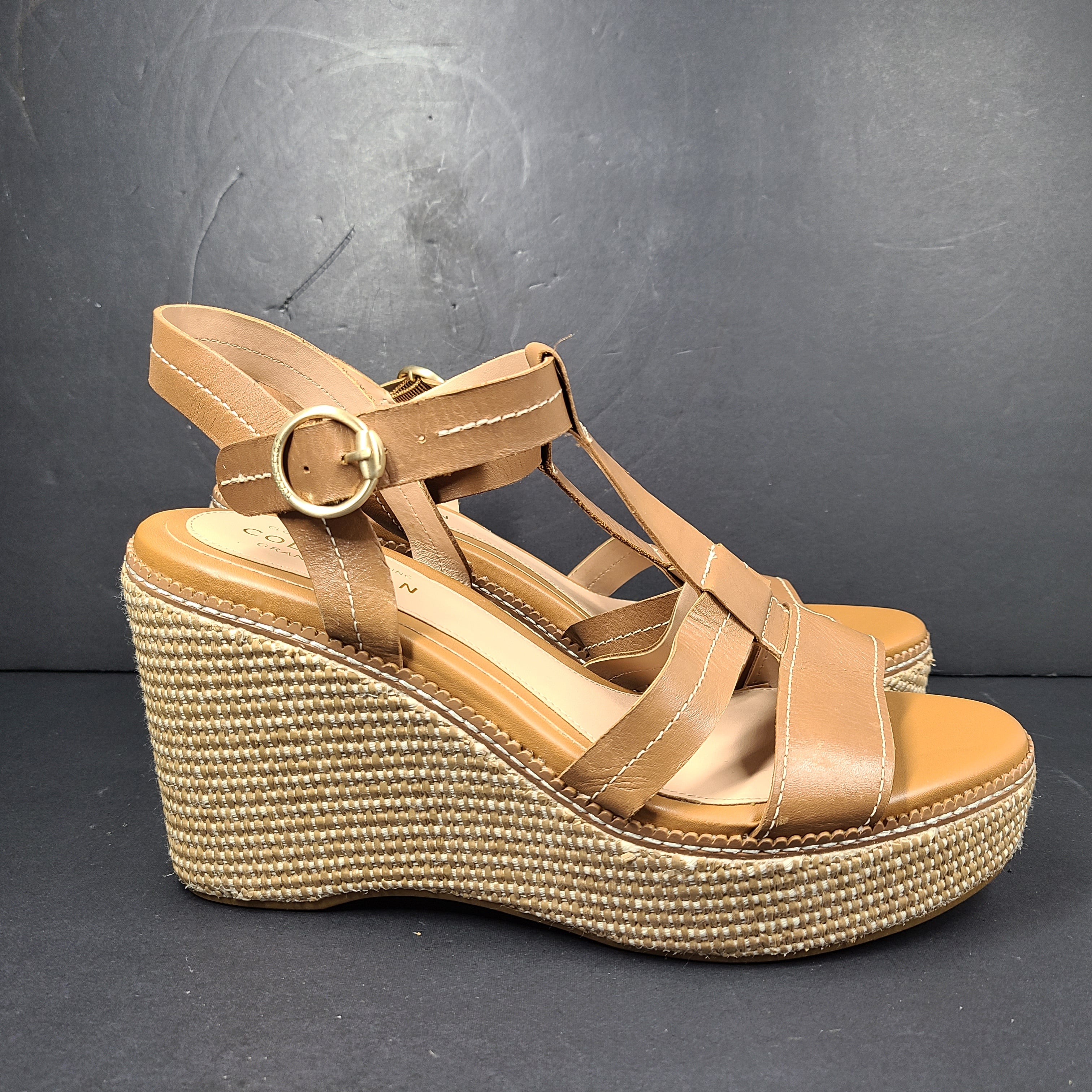 A pair of tan Cole Haan Cloudfeel Grandseries wedge sandals for women
