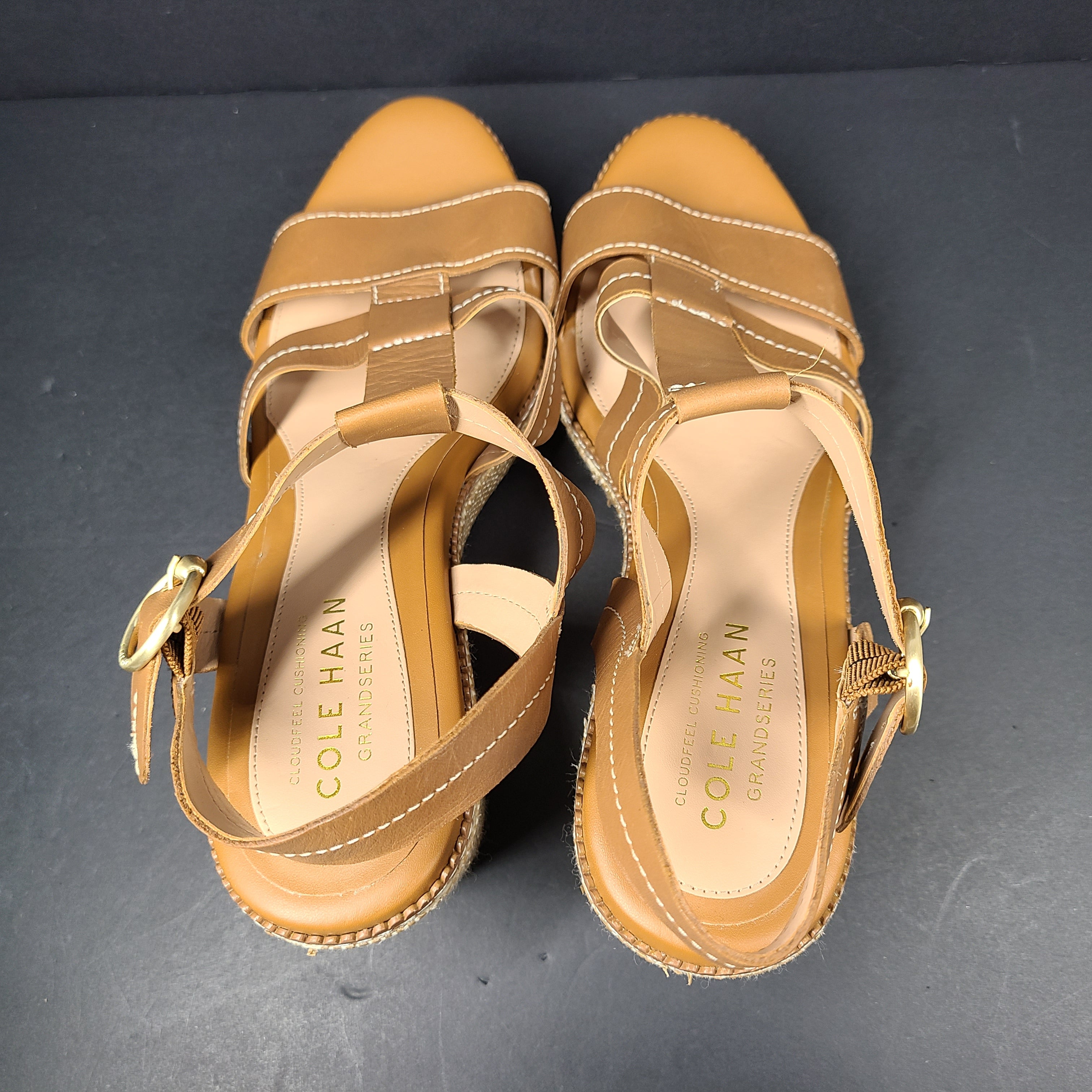 A pair of tan Cole Haan Cloudfeel Grandseries wedge sandals for women