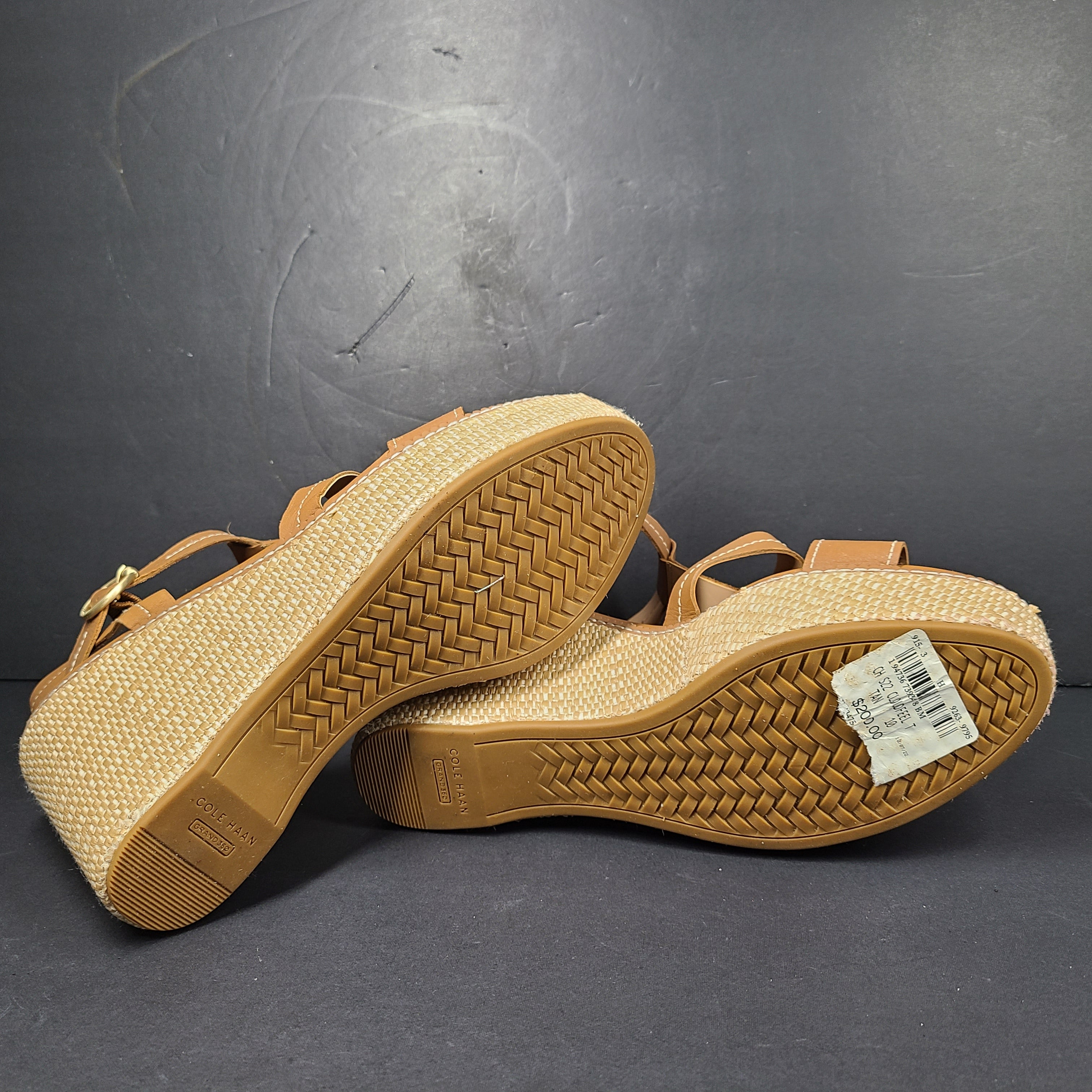 A pair of tan Cole Haan Cloudfeel Grandseries wedge sandals for women