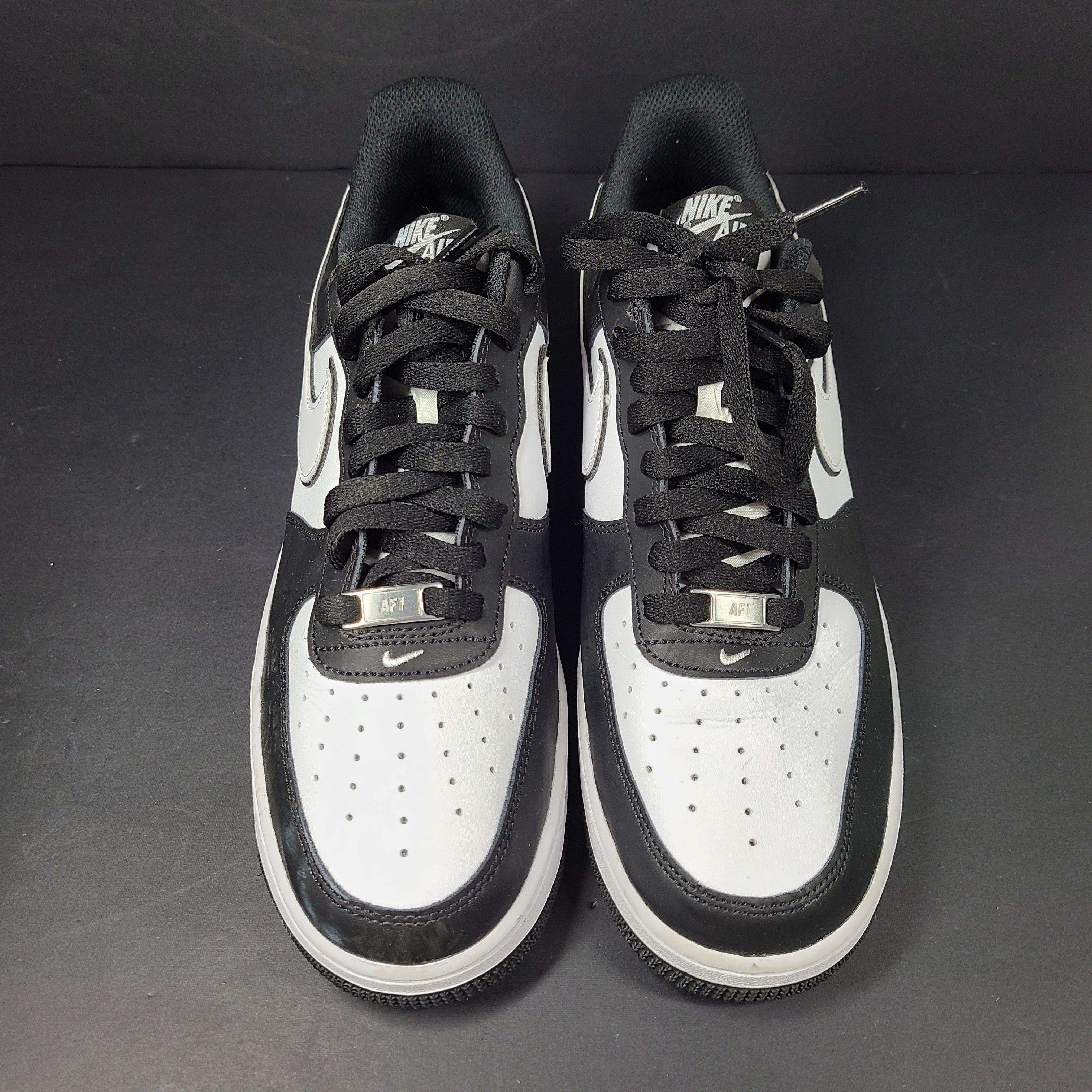 A stylish pair of Nike Air Force 1 Low sneakers in black and white.