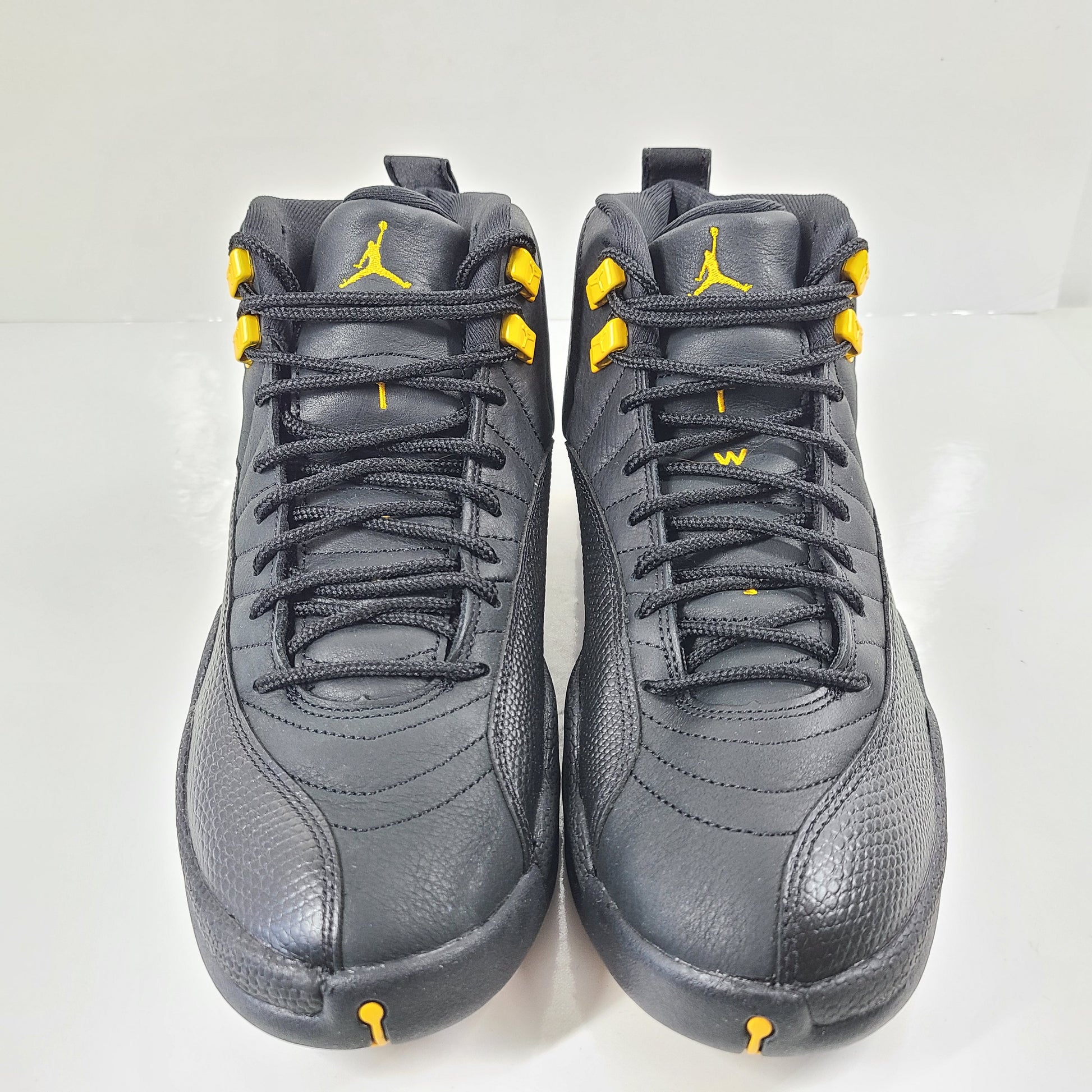 A pair of black and yellow Nike Air Jordan 12 Retro sneakers