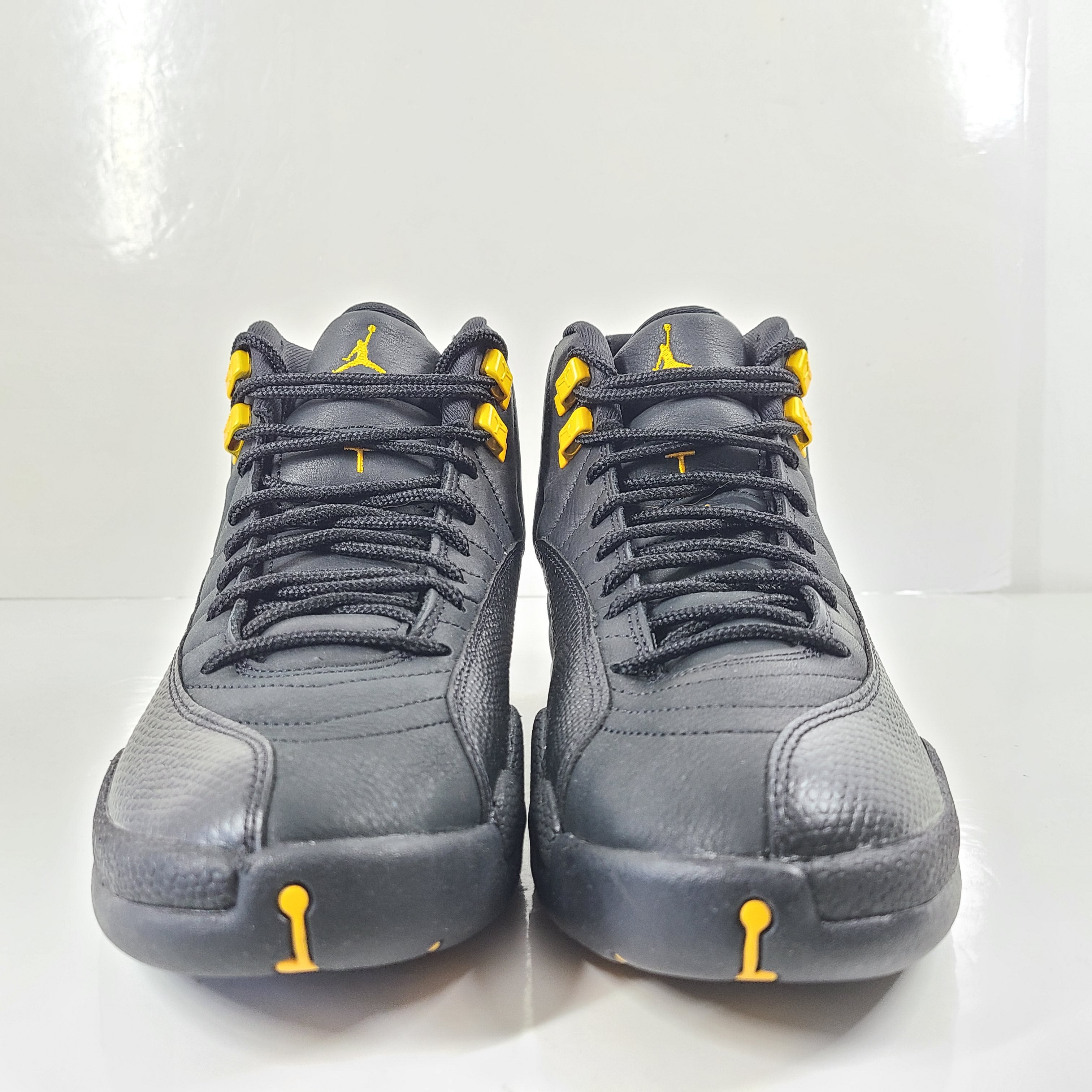 A pair of black and yellow Nike Air Jordan 12 Retro sneakers