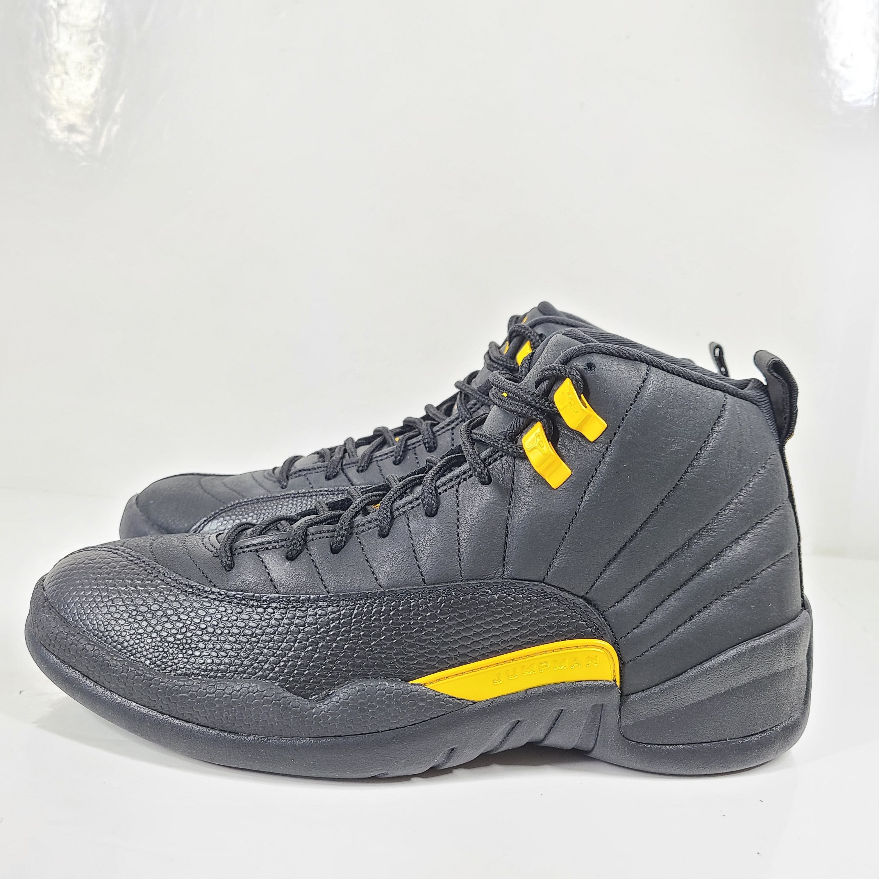 A pair of black and yellow Nike Air Jordan 12 Retro sneakers
