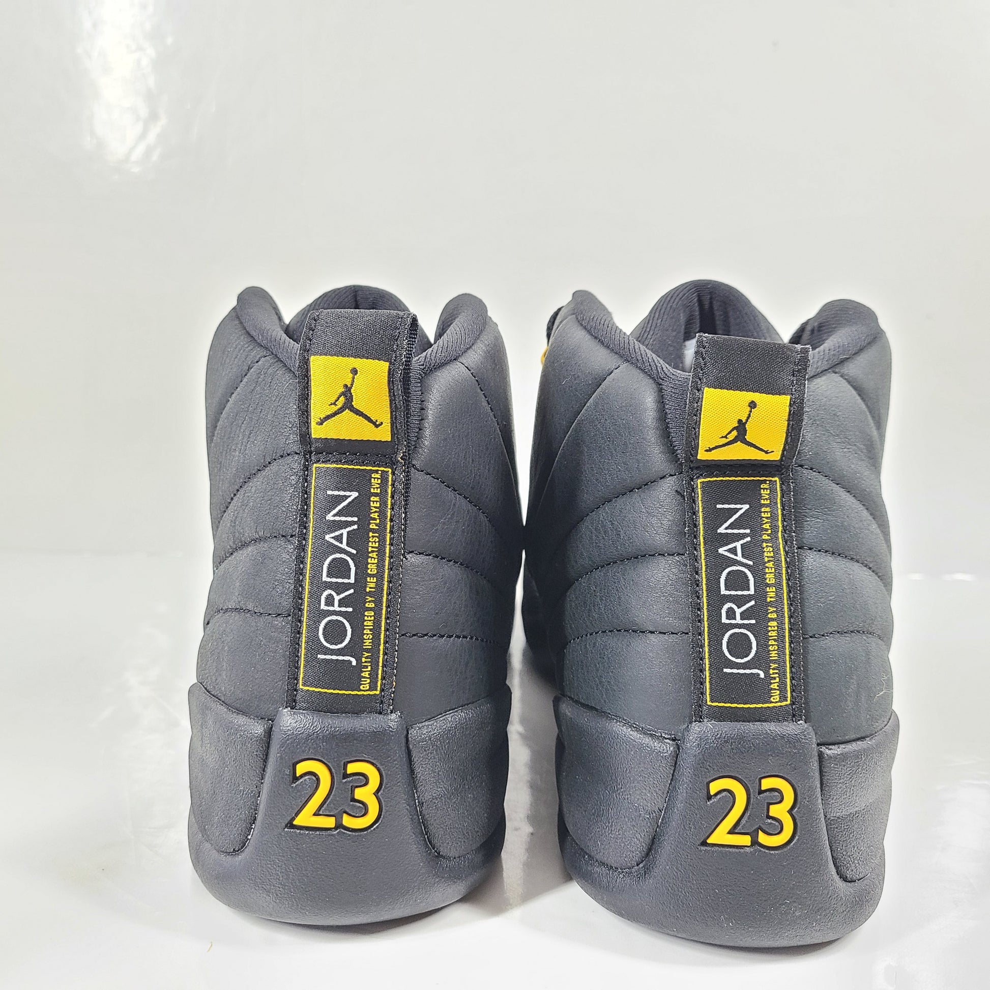 A pair of black and yellow Nike Air Jordan 12 Retro sneakers