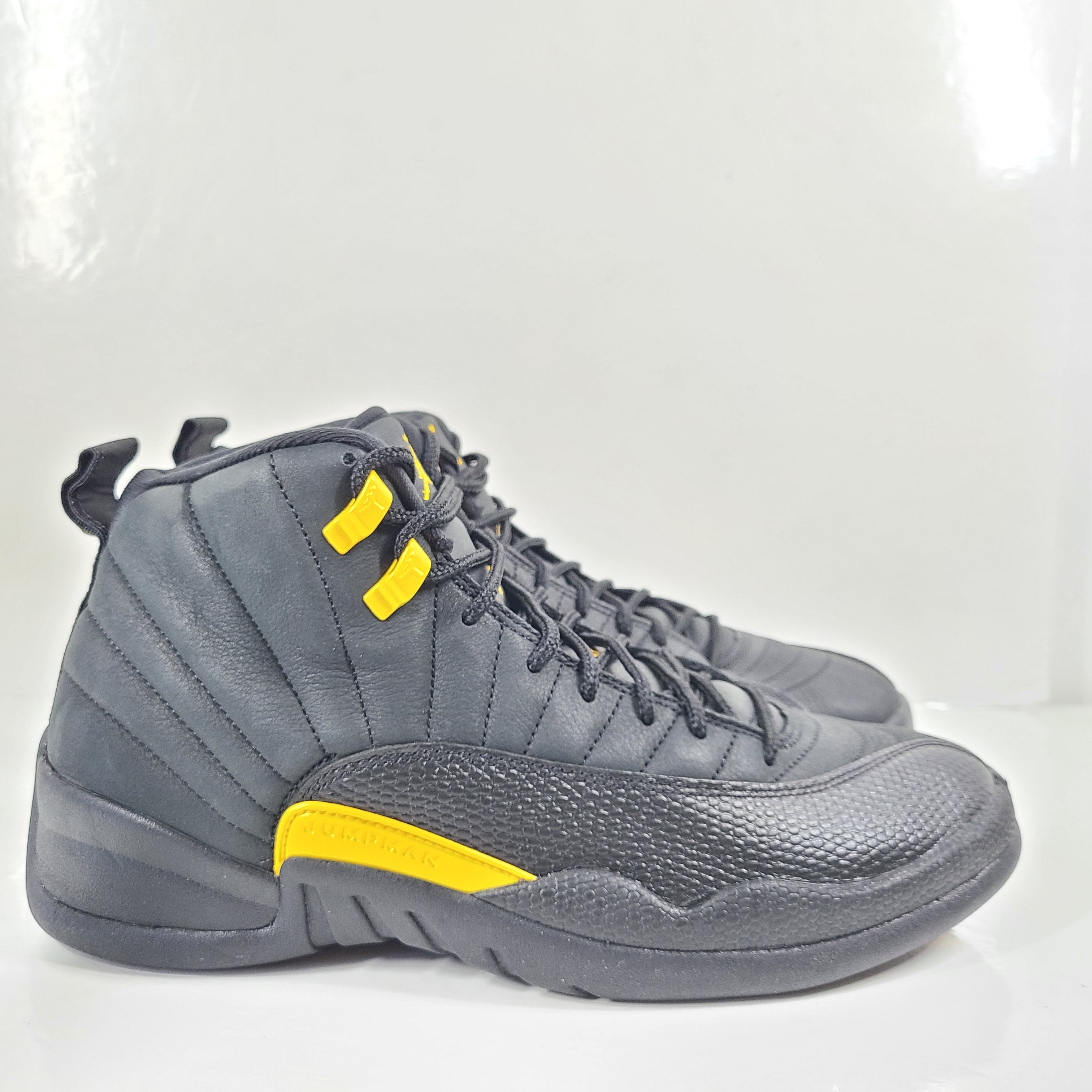 A pair of black and yellow Nike Air Jordan 12 Retro sneakers