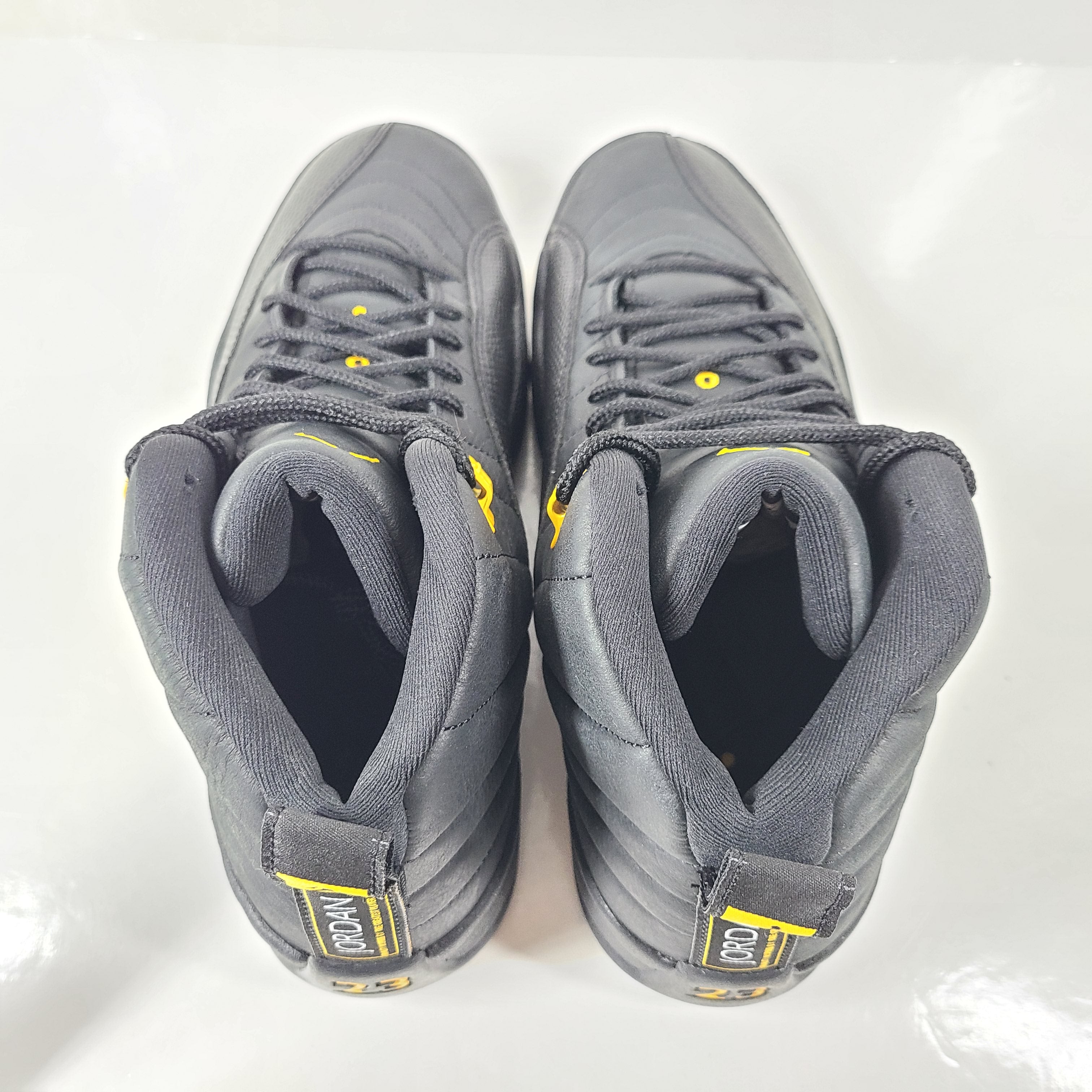A pair of black and yellow Nike Air Jordan 12 Retro sneakers
