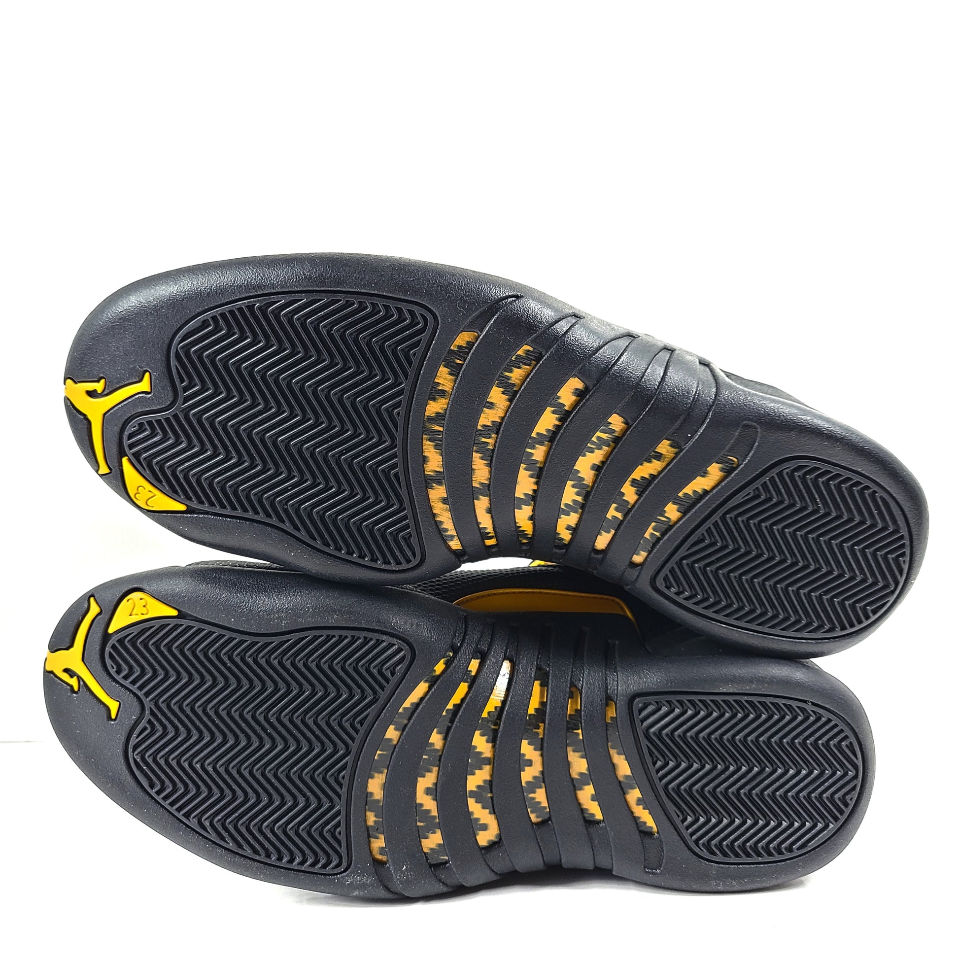 A pair of black and yellow Nike Air Jordan 12 Retro sneakers