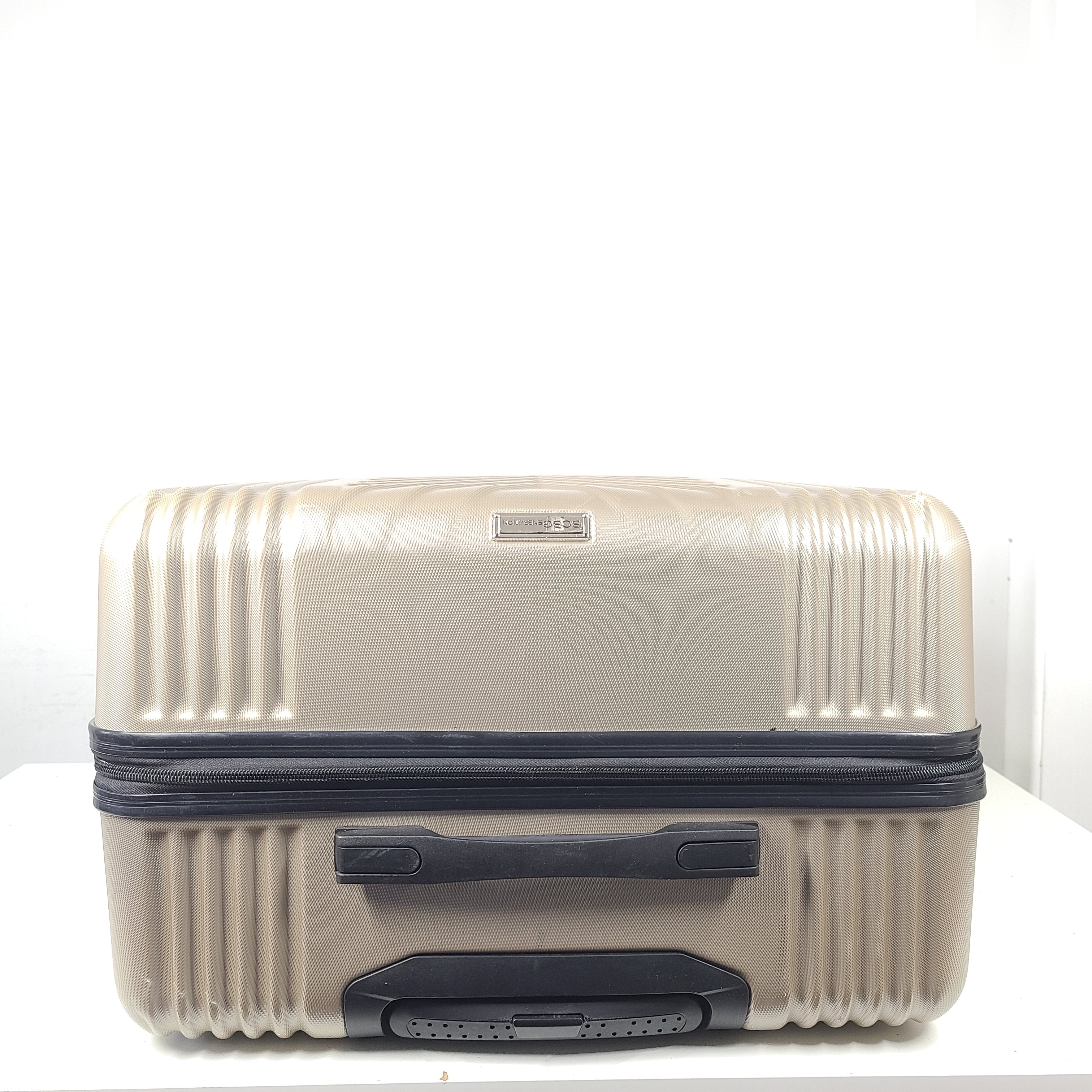 A stylish gold BCBGeneration suitcase made of 100% ABS material.