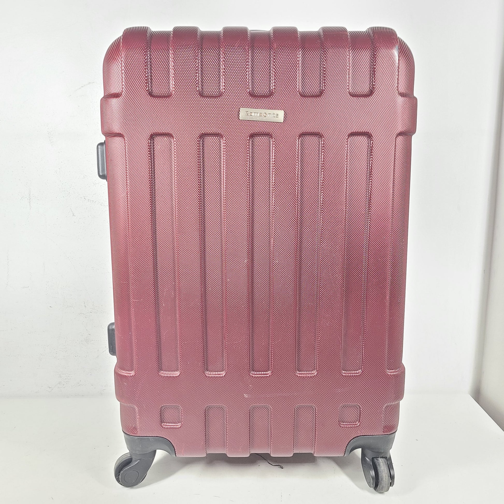 A burgundy Samsonite hardside spinner suitcase
