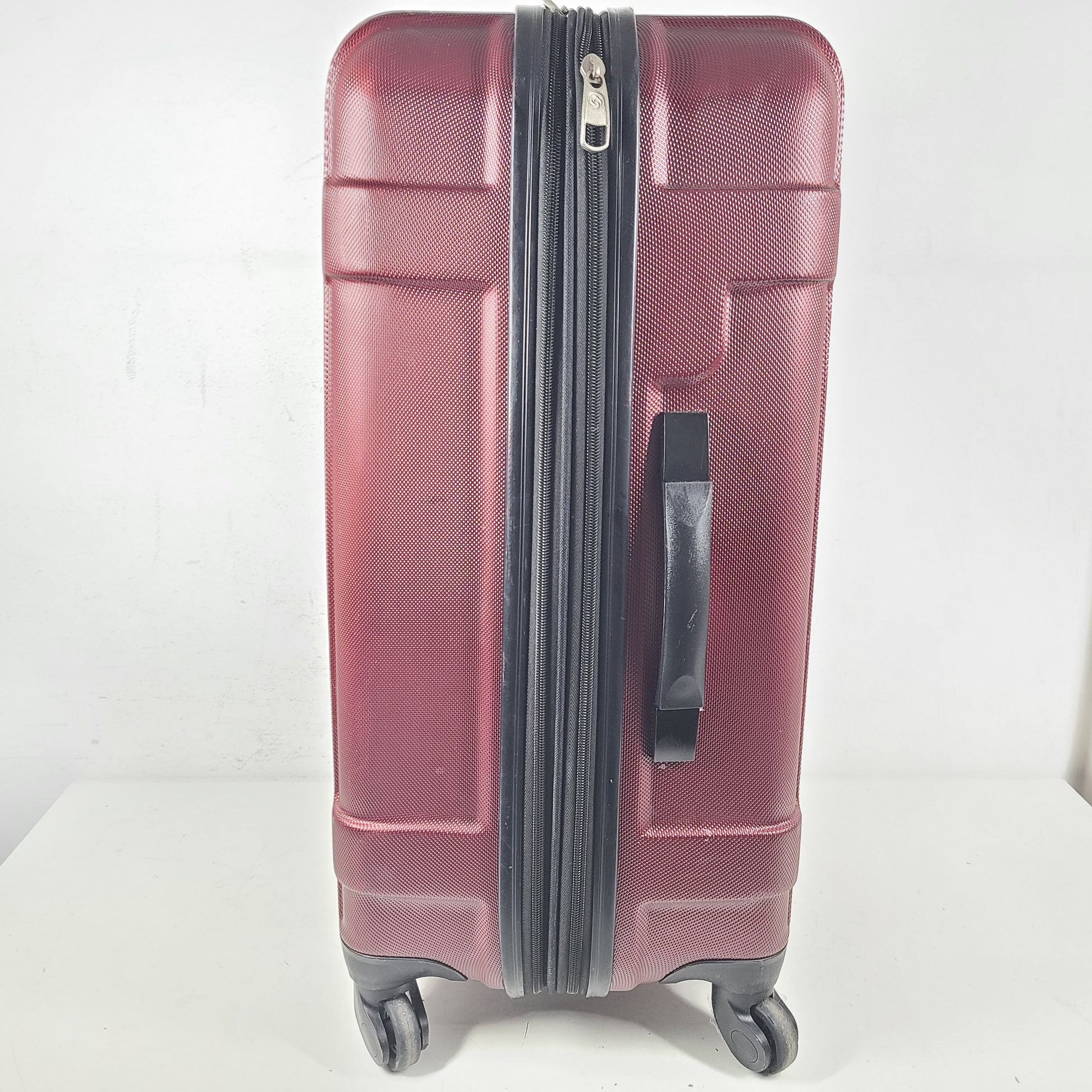 A burgundy Samsonite hardside spinner suitcase