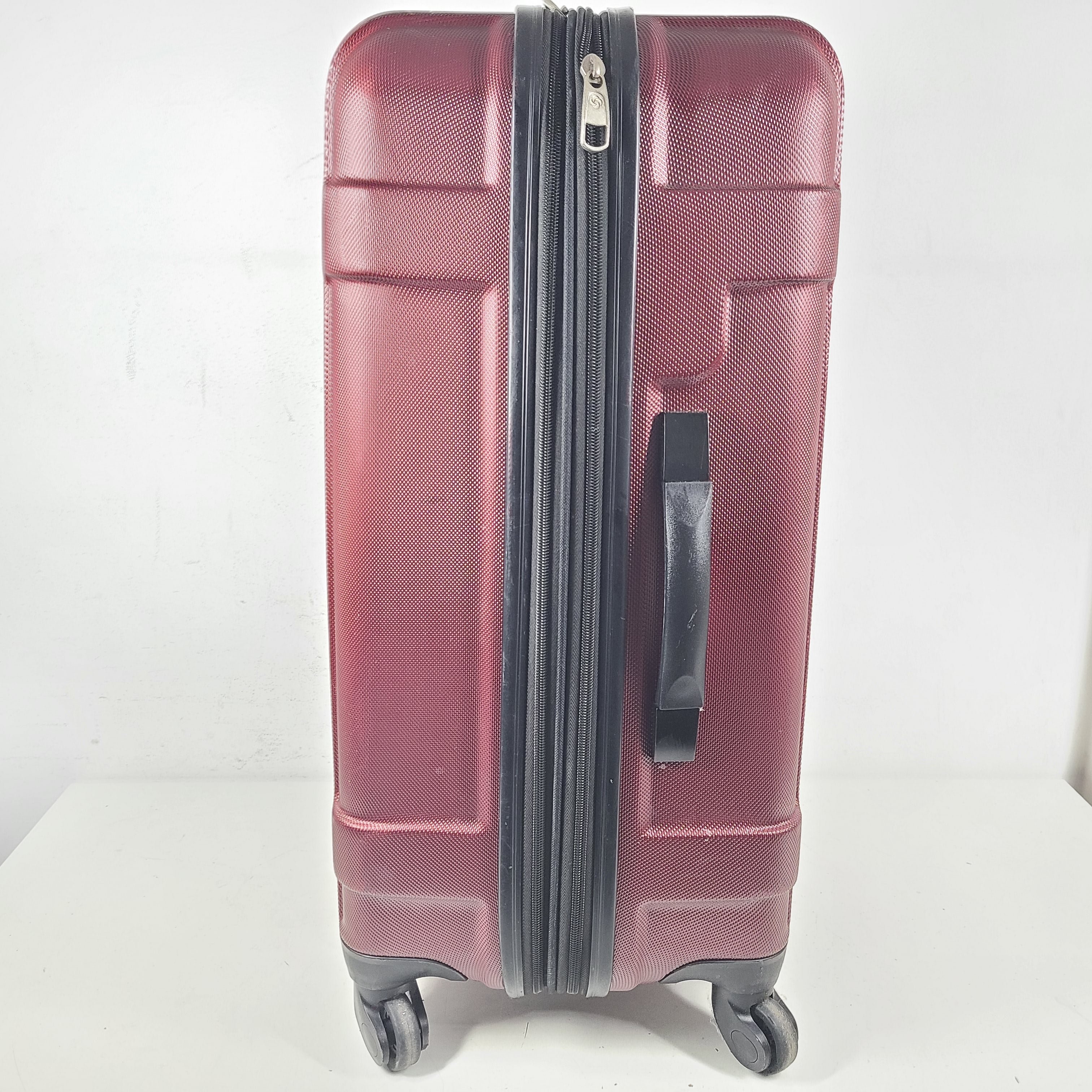 A burgundy Samsonite hardside spinner suitcase
