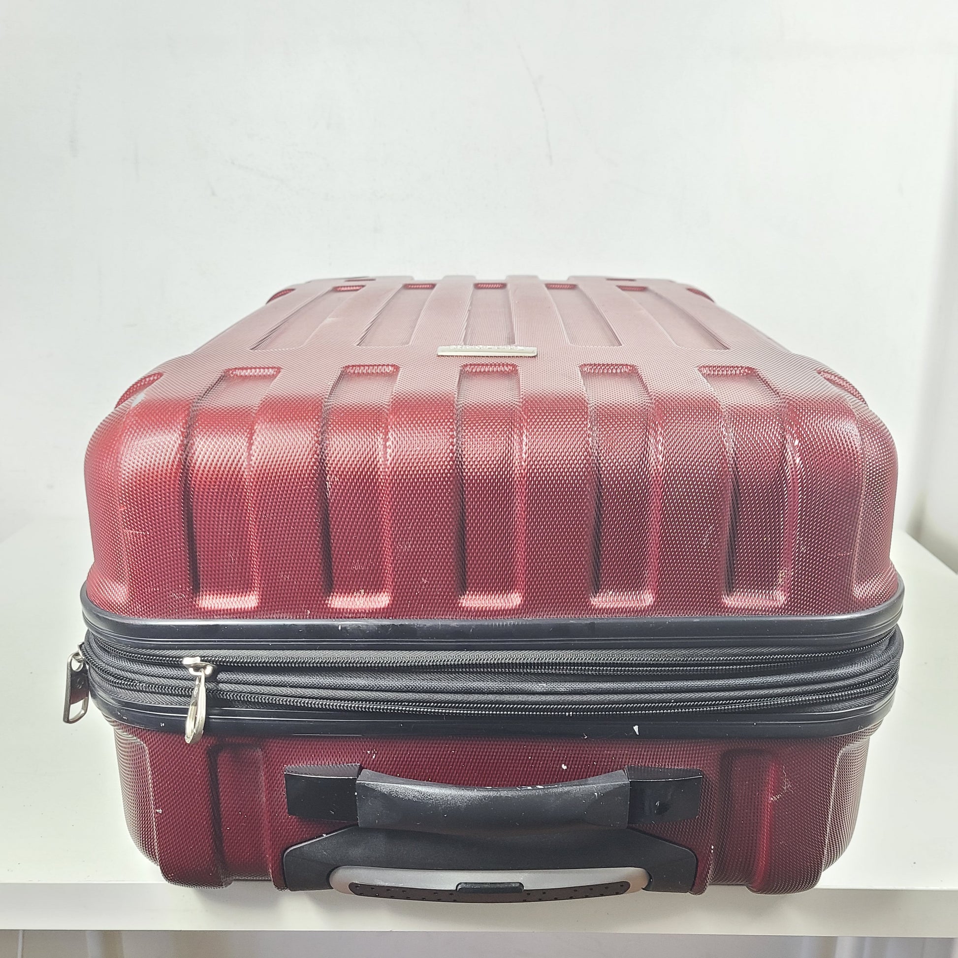 A burgundy Samsonite hardside spinner suitcase