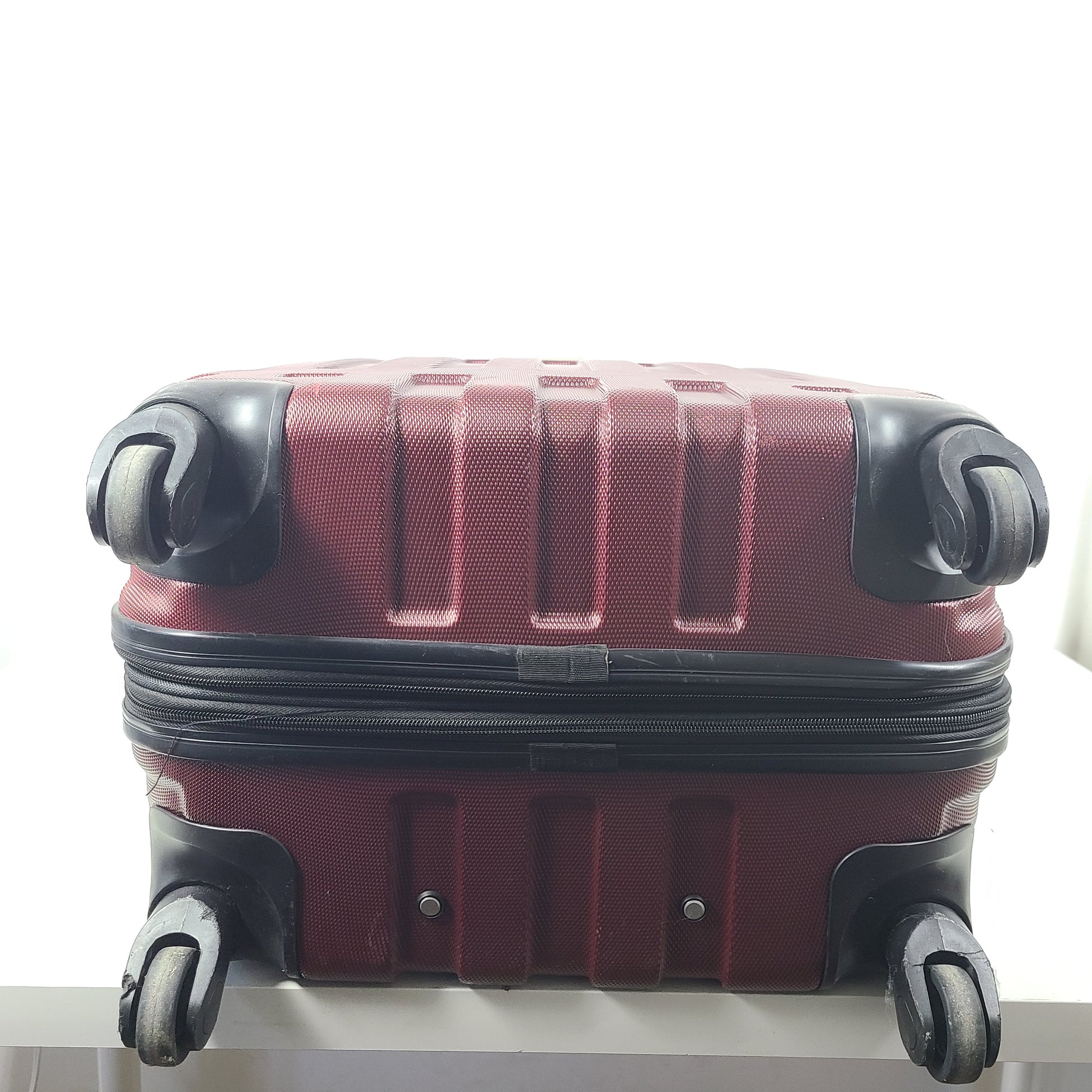 A burgundy Samsonite hardside spinner suitcase