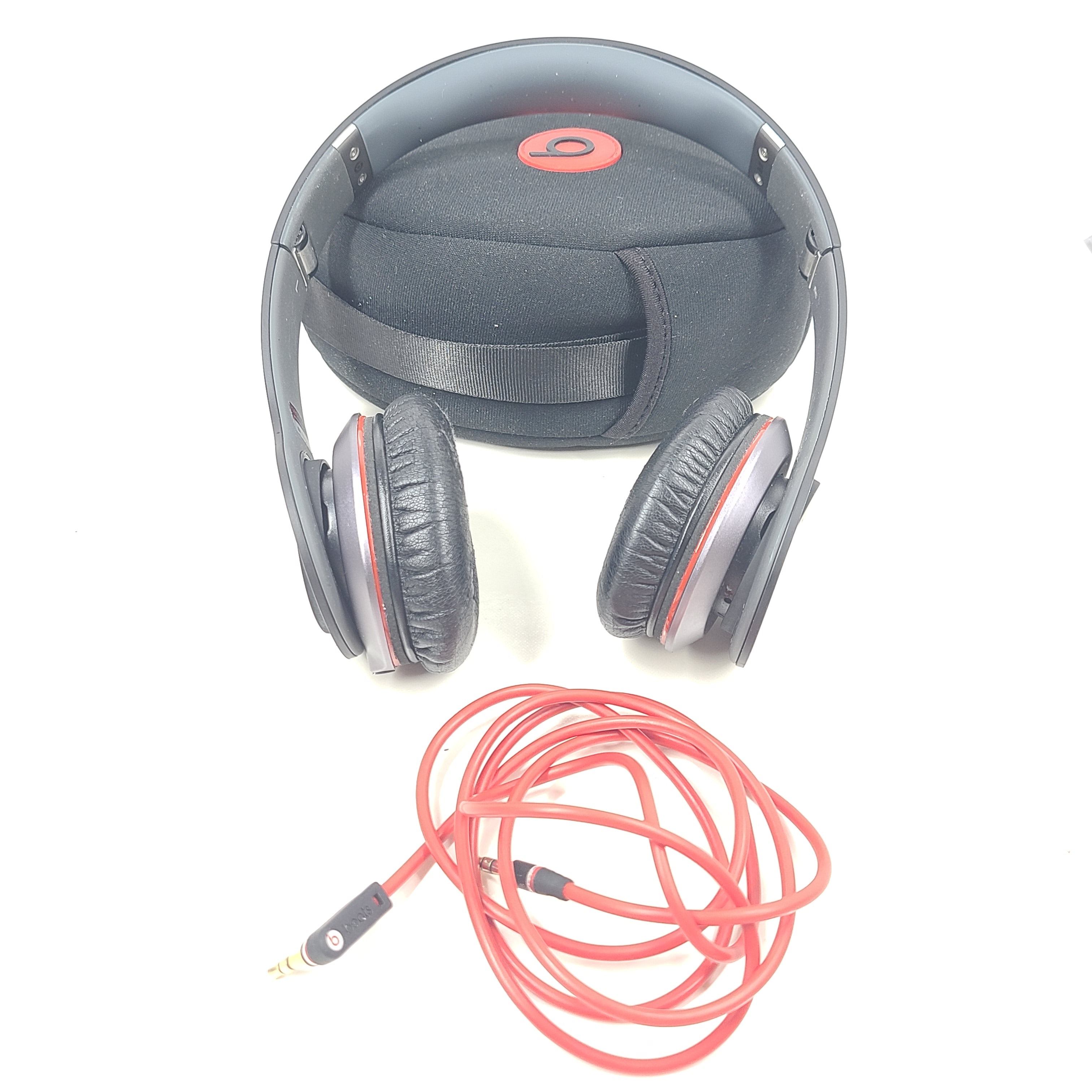 A pair of black and red Beats by Dr. Dre Solo HD Wired Headphones with case