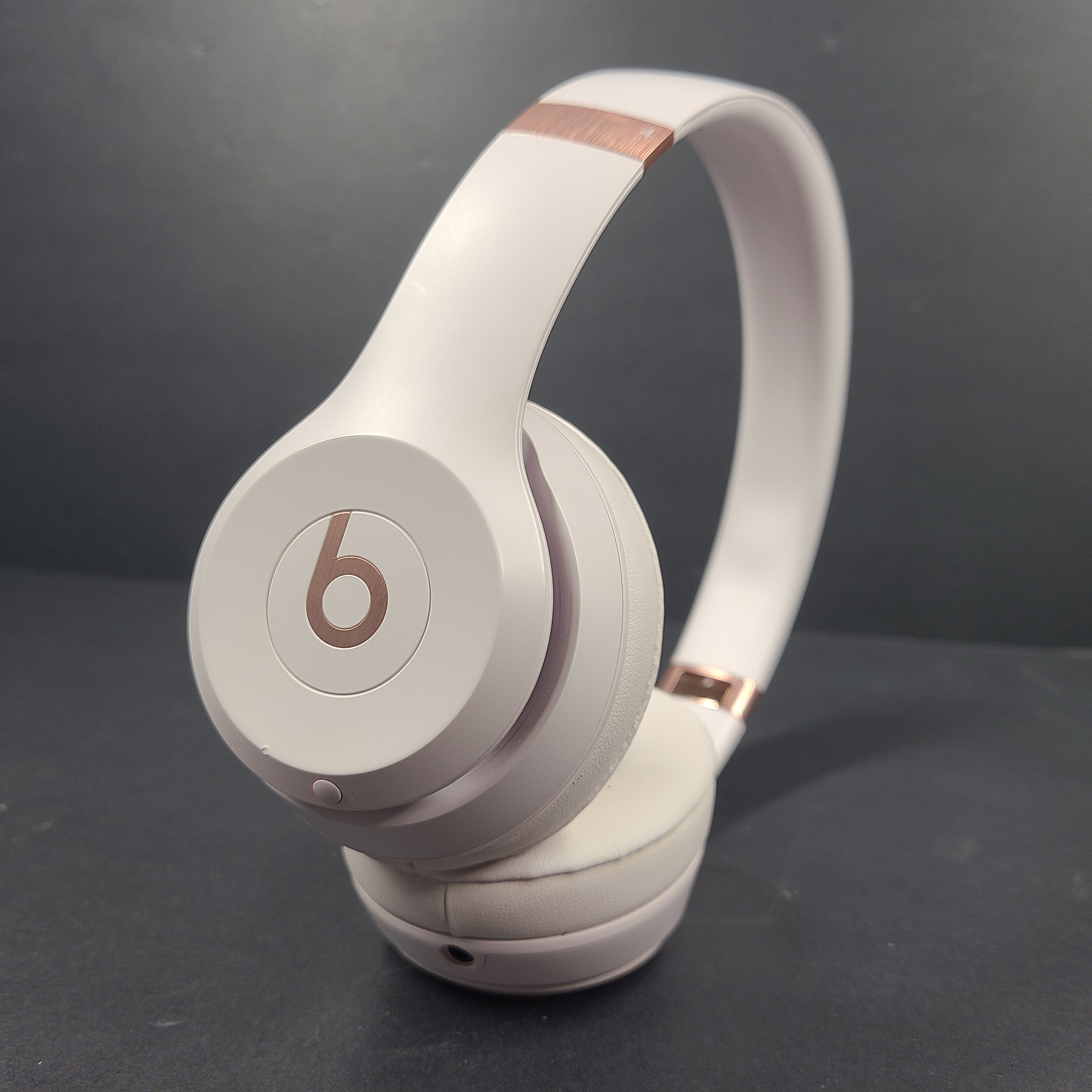 A pair of stylish on-ear headphones in white and rose gold