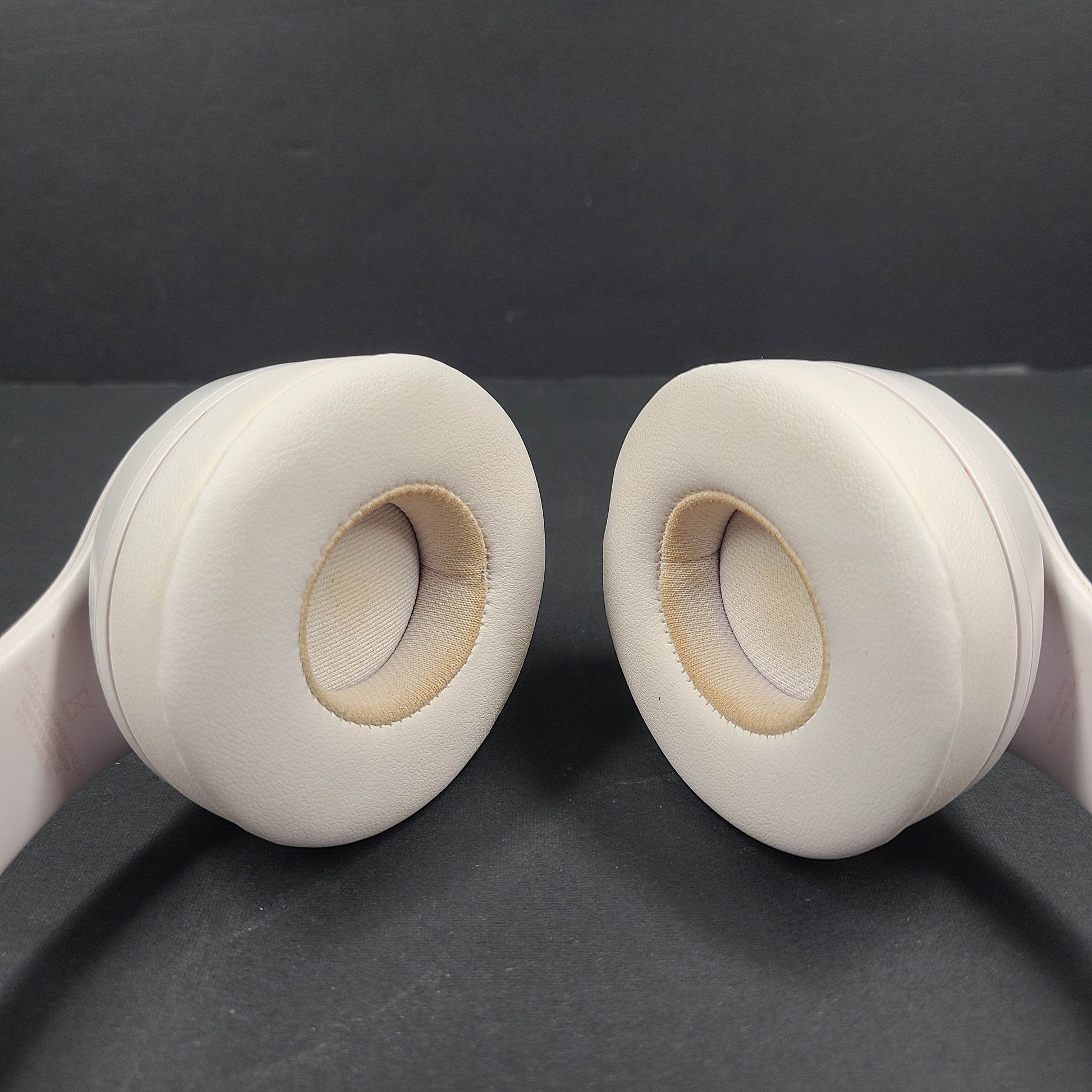 A pair of stylish on-ear headphones in white and rose gold