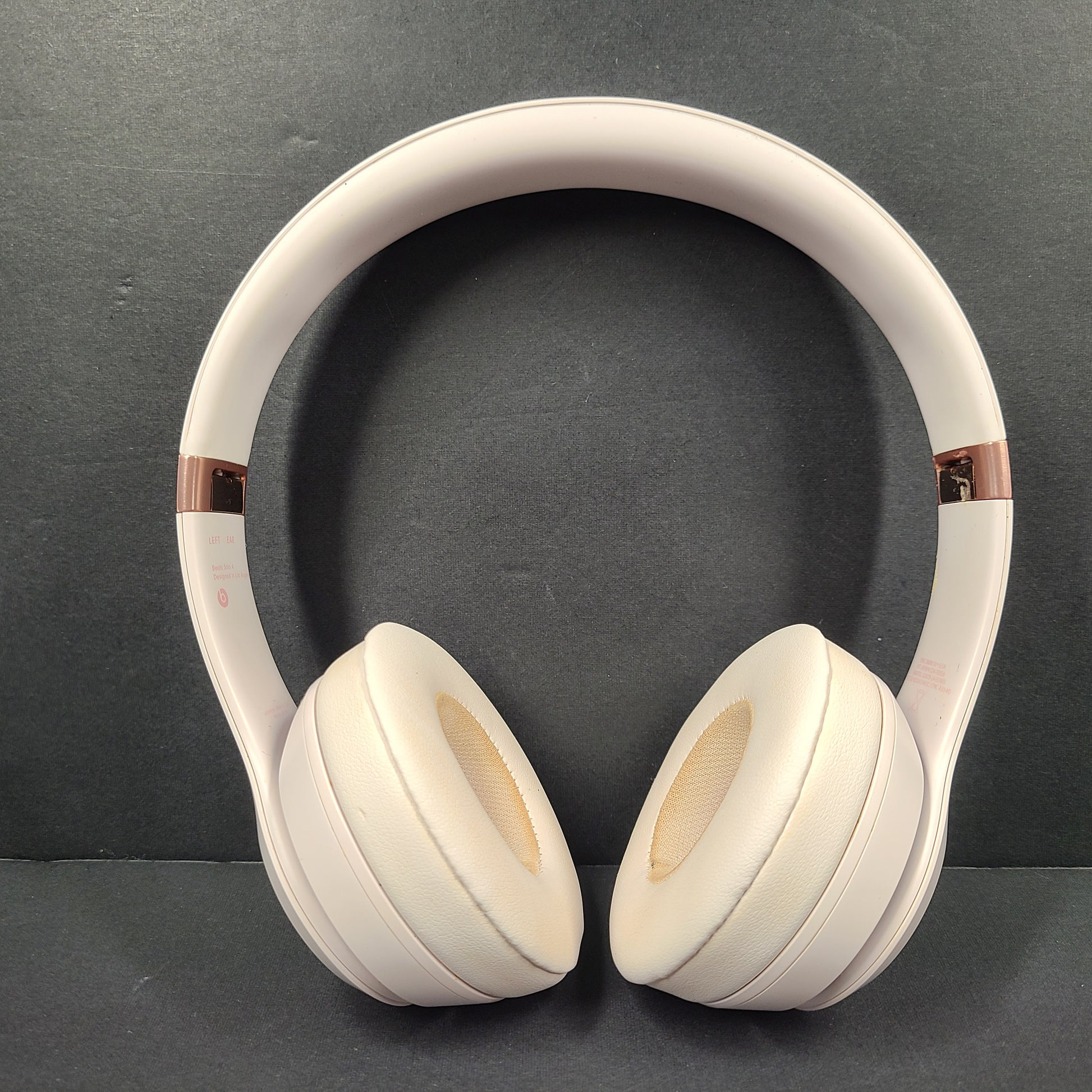 A pair of stylish on-ear headphones in white and rose gold