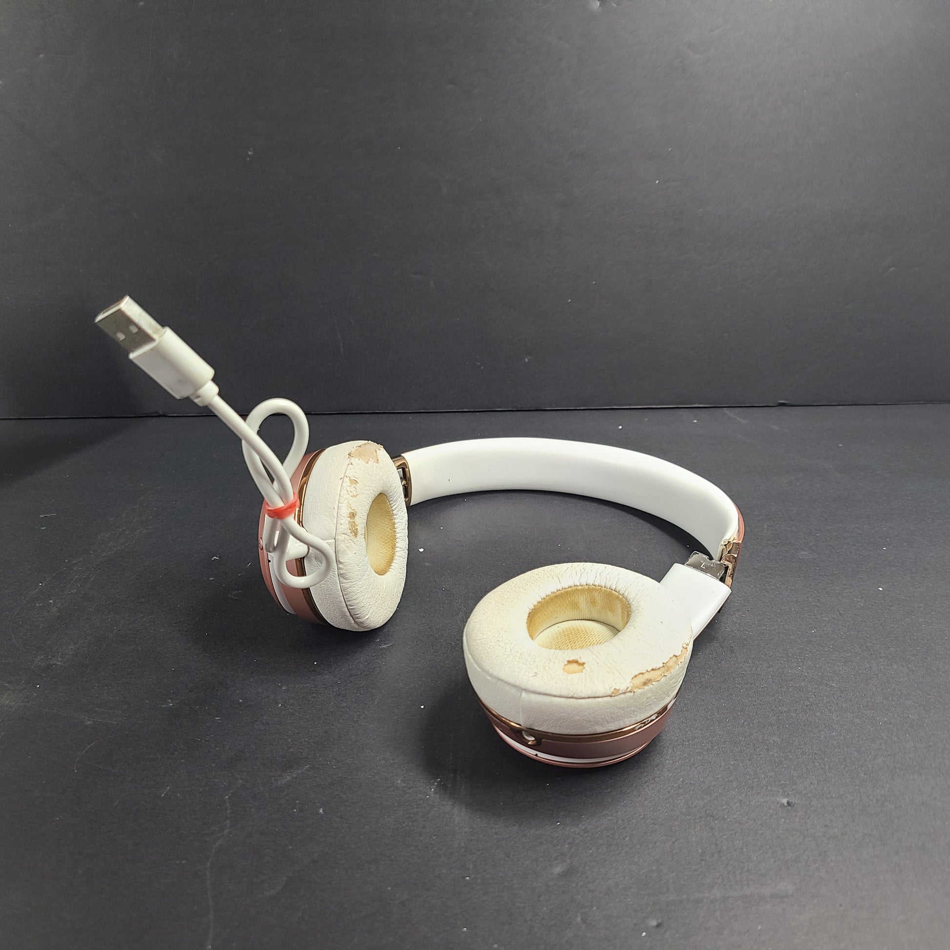 A stylish pair of rose gold wireless on-ear headphones offering premium sound and long-lasting comfort