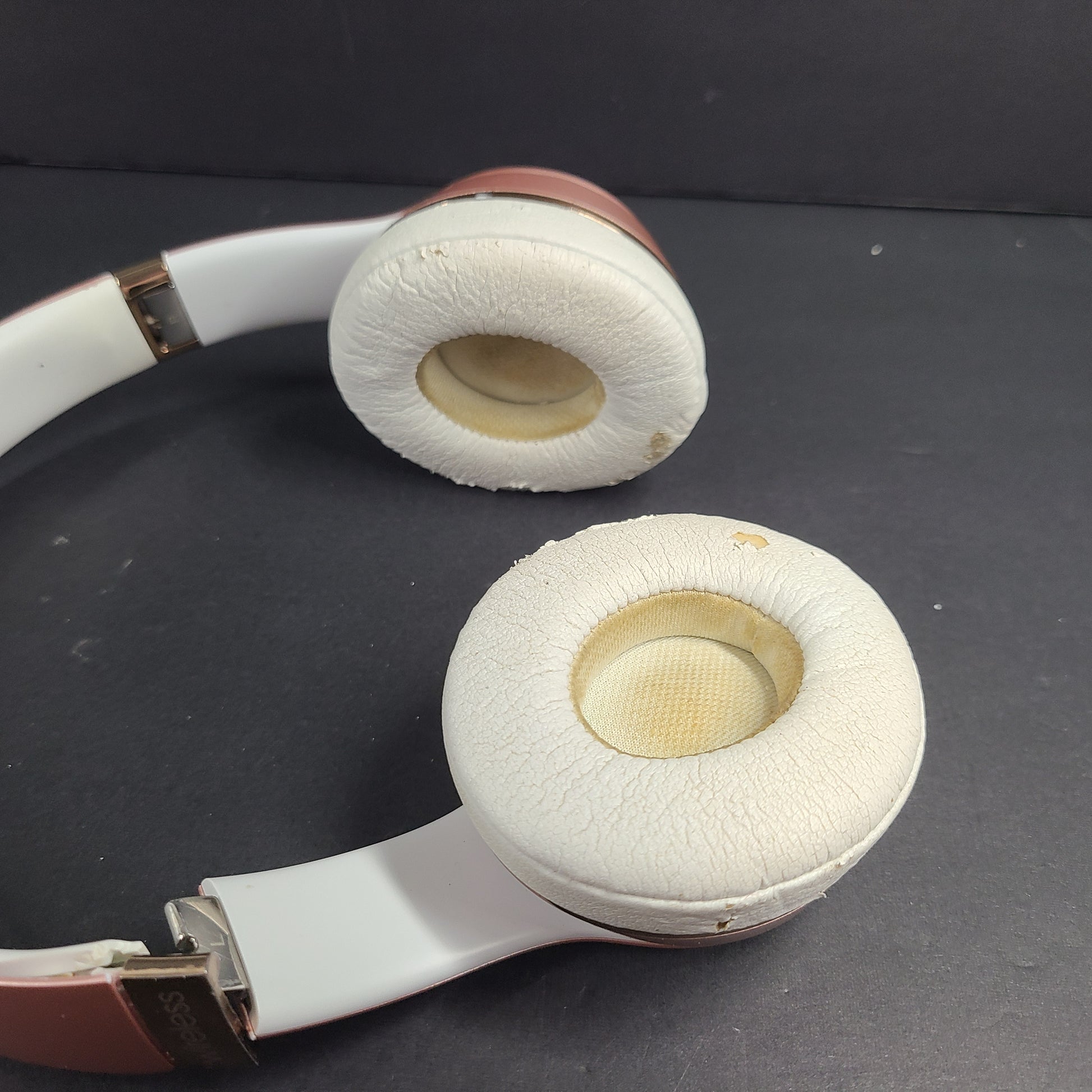 A stylish pair of rose gold wireless on-ear headphones offering premium sound and long-lasting comfort